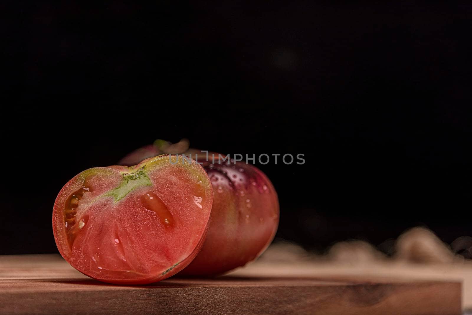Beautiful fresh tiger tomatoes on dark background