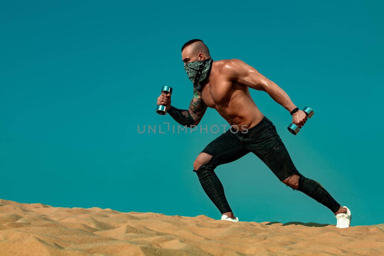 Sporty and fit young woman athlete training at the desert. Cloudy day on coast. The concept of a healthy lifestyle and sport. Woman in white sportswear.