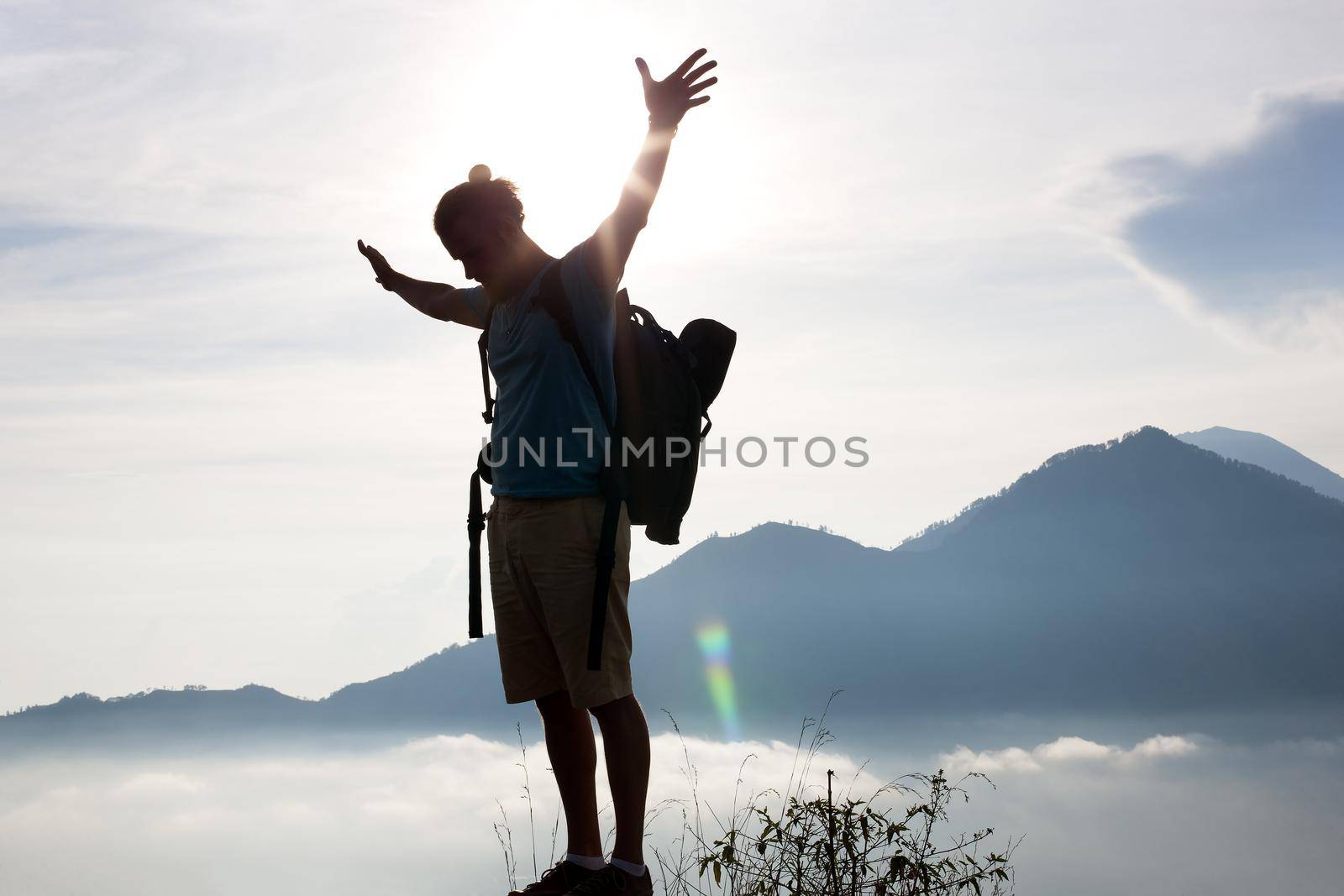 Hiker walking along a mountain path. Sunrise on top of mountain