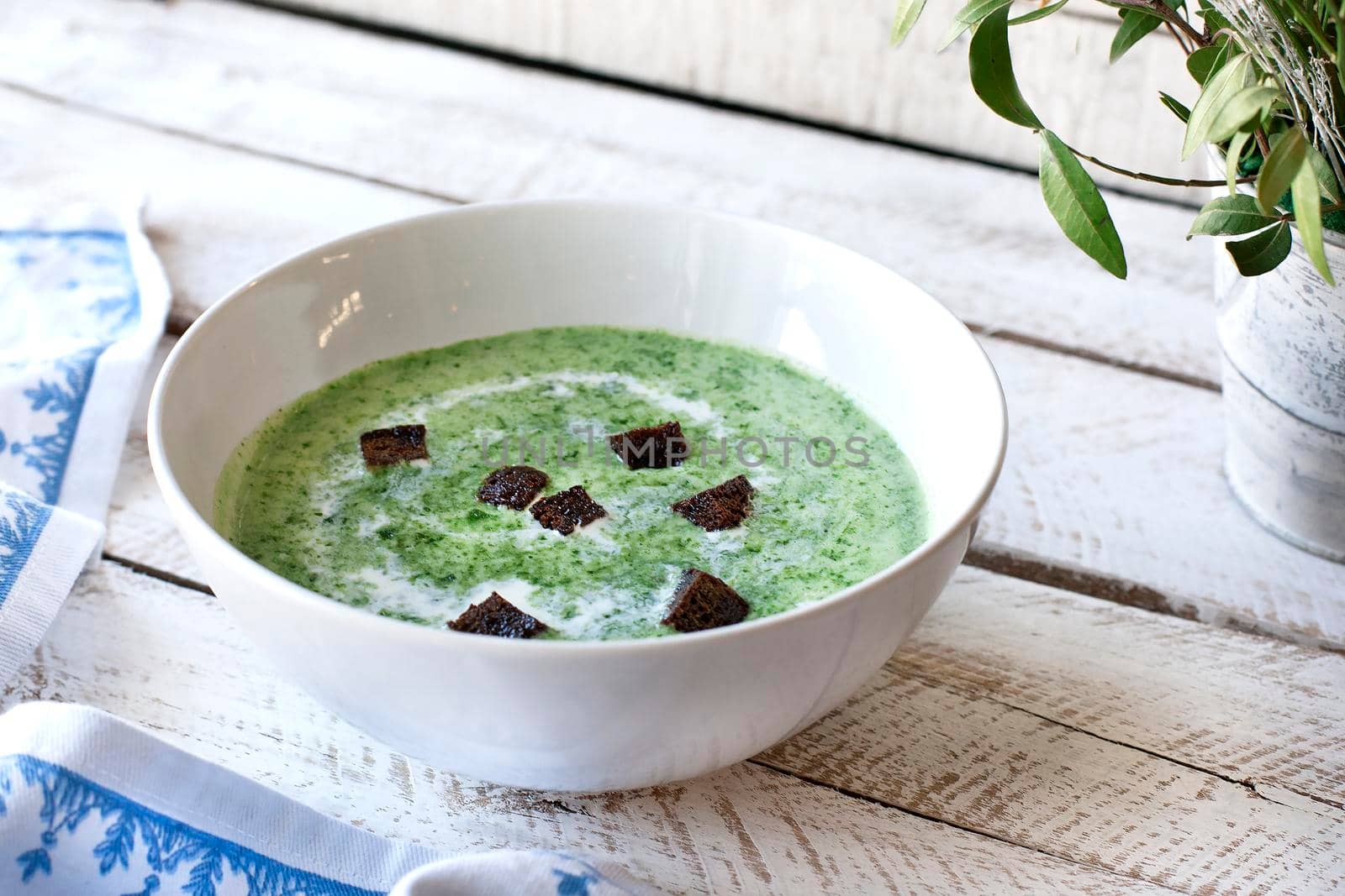 Spinach soup on wooden table by Jyliana