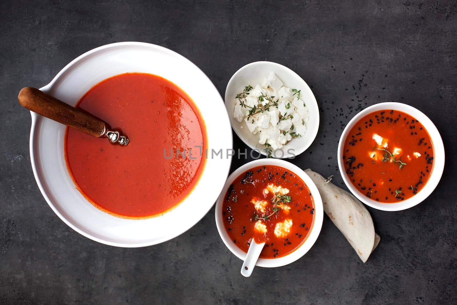 Tomato soup with pita and feta cheese on the gray background- Stock image