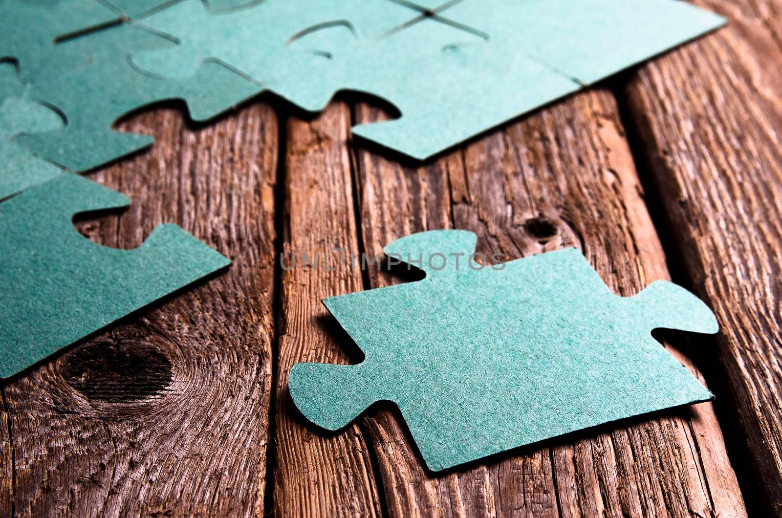 Incomplete puzzles lying on wooden rustic boards. by Jyliana