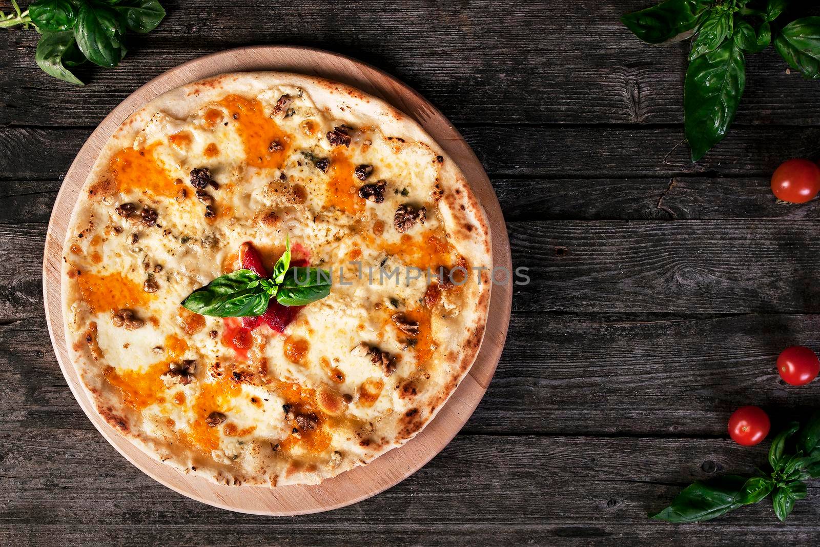 Delicious fresh Pizza with walnuts, cheese and tomato paste on the wooden background. Top view.