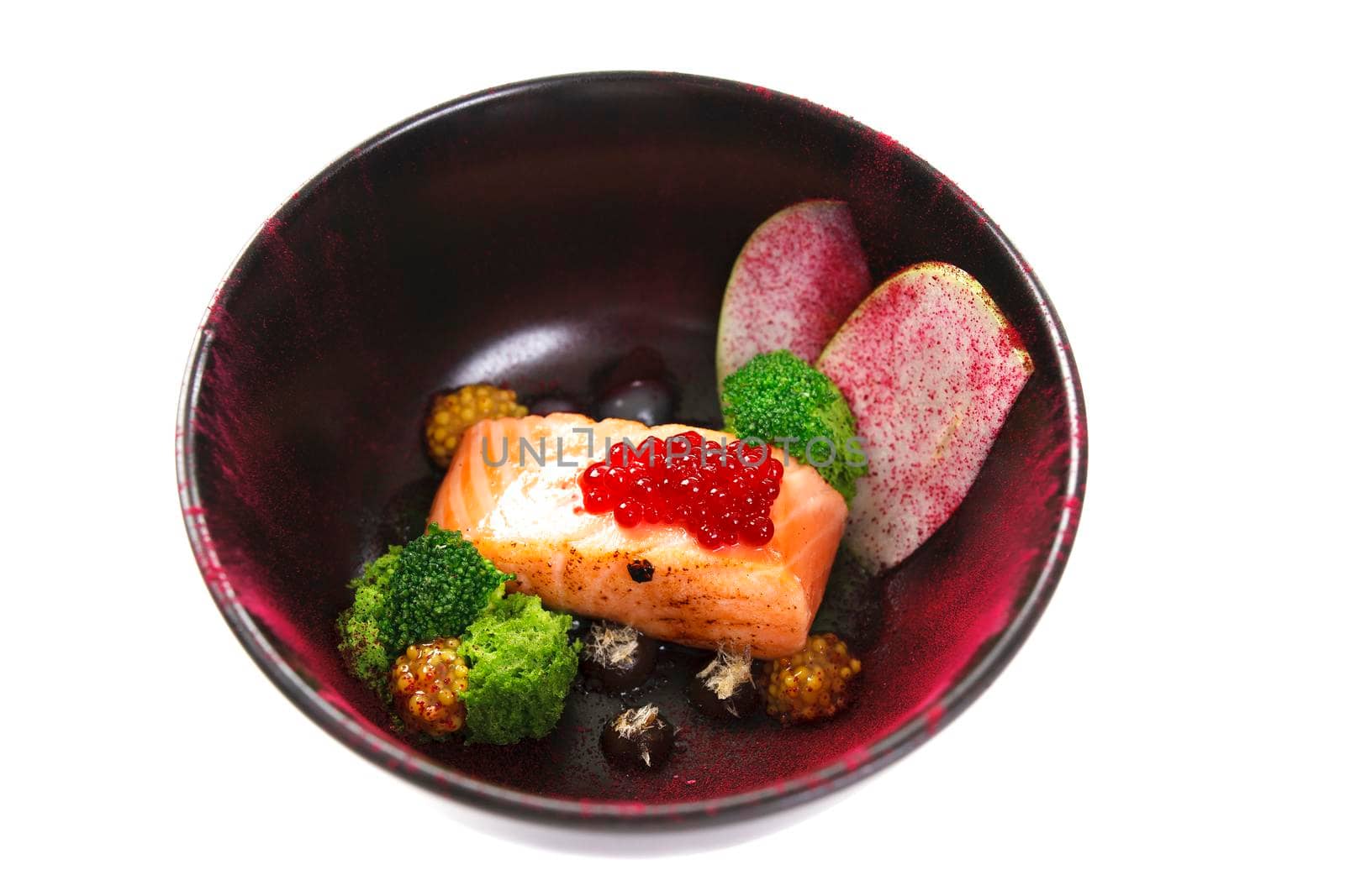 Molecular modern cuisine red fish in a dish with beautiful garnish close up. Isolated