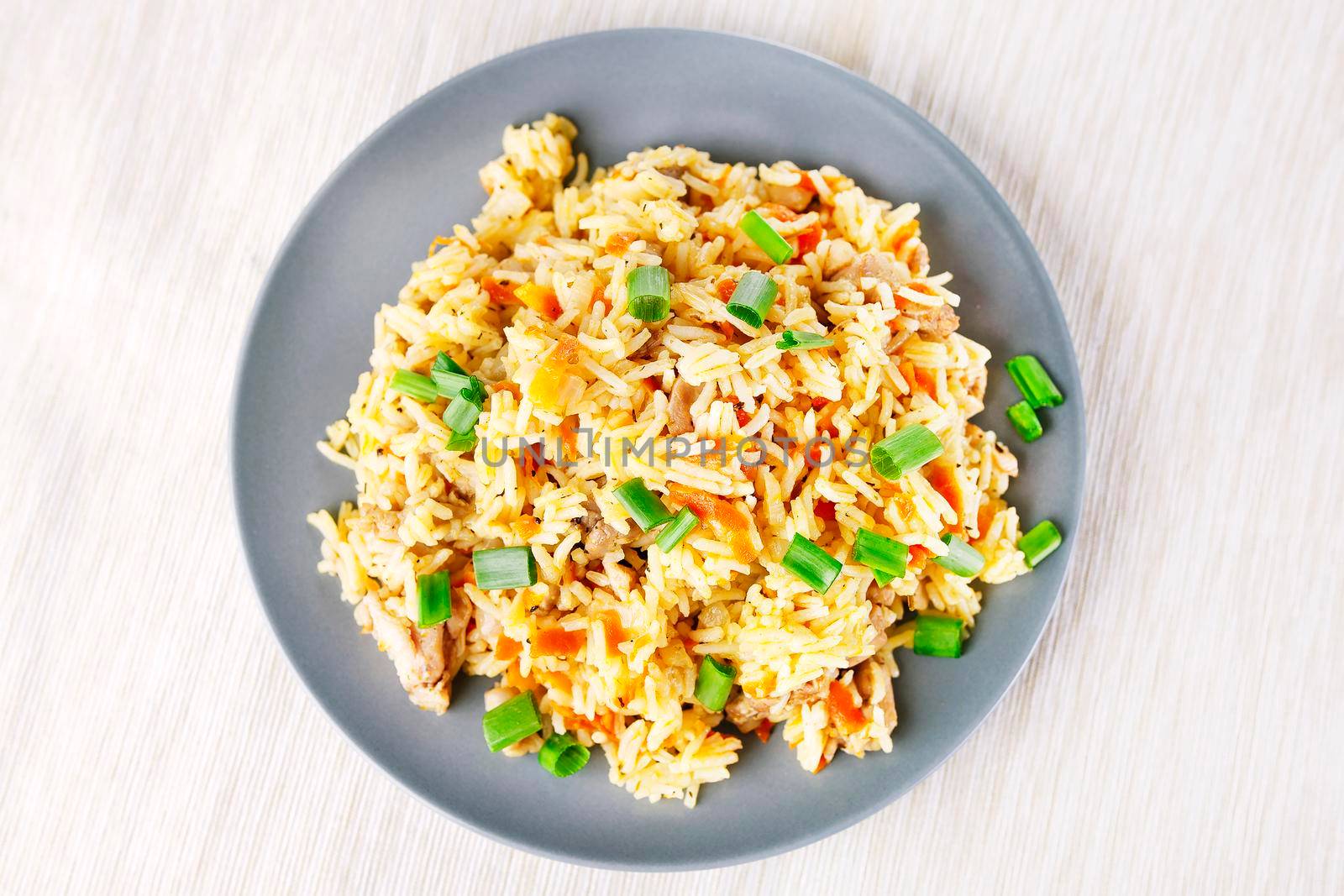 Fragrant Pilau Pulav pilaf pilaf, fried rice with meat and vegetables on a grey plate. Isolated on white. Macro.