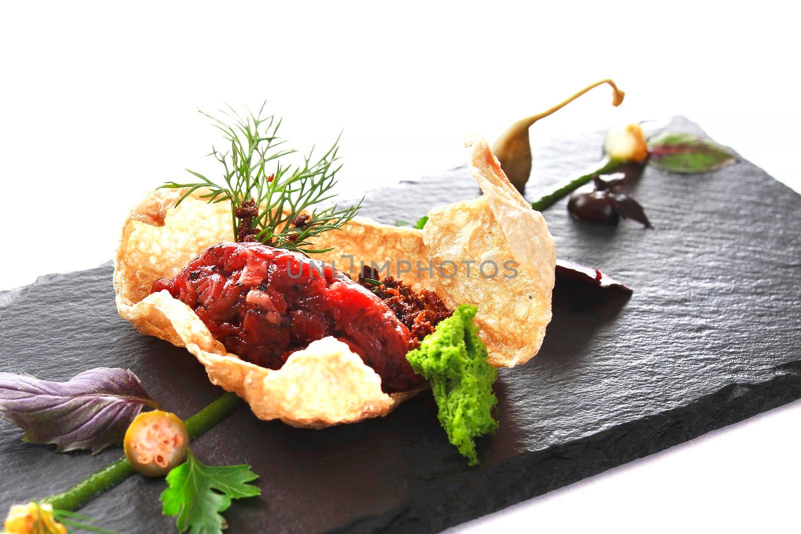 Molecular modern cuisine. Chips Pigskin with tartare or carpaccio of beef. Stock image. Isolated on white.