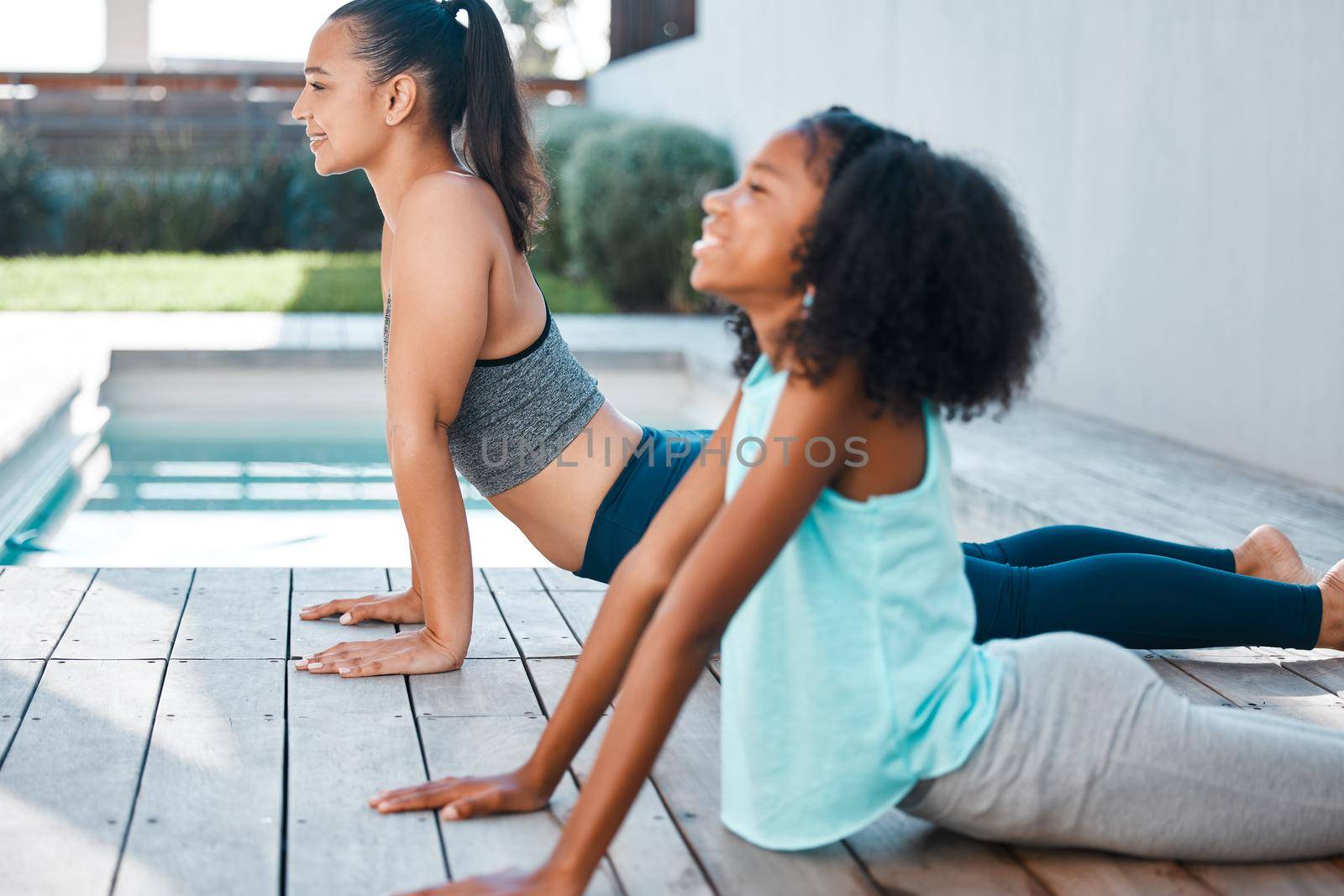 Shot of a young mother and daughter practicing yoga outside.