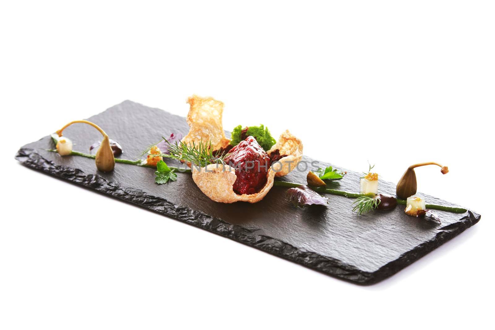 Molecular modern cuisine. Chips Pigskin with tartare or carpaccio of beef. Stock image. Isolated on white.