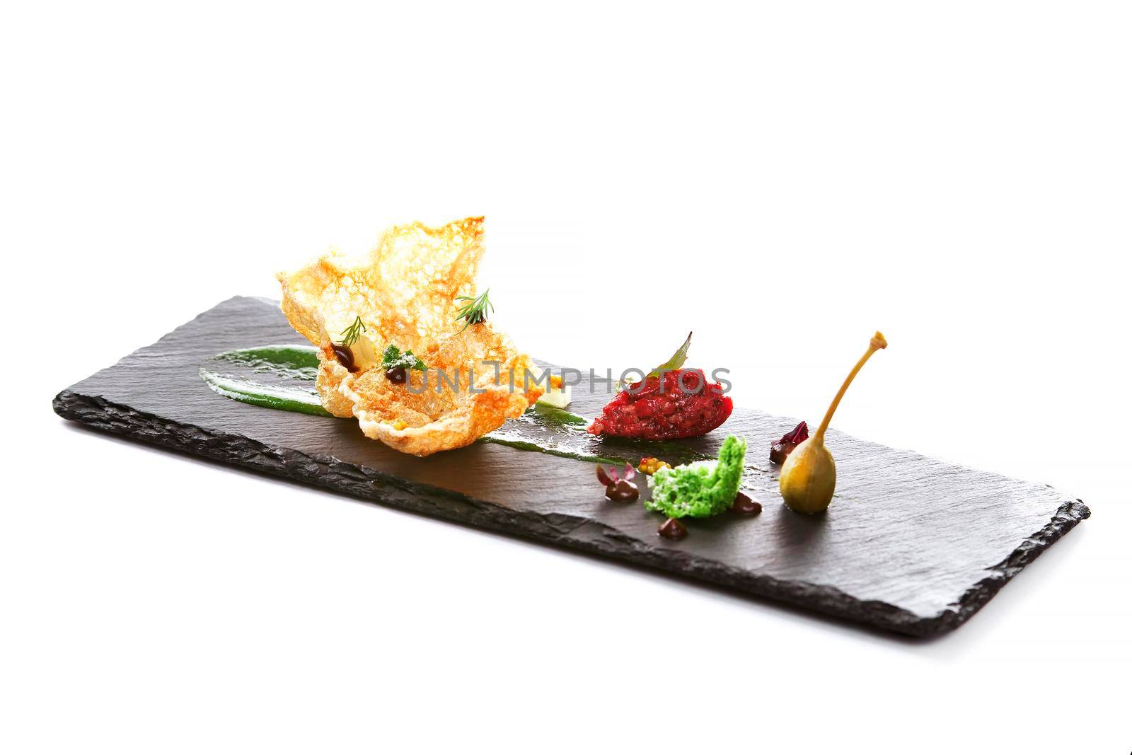 Molecular modern cuisine. Chips Pigskin with tartare or carpaccio of beef. Stock image. Isolated on white.