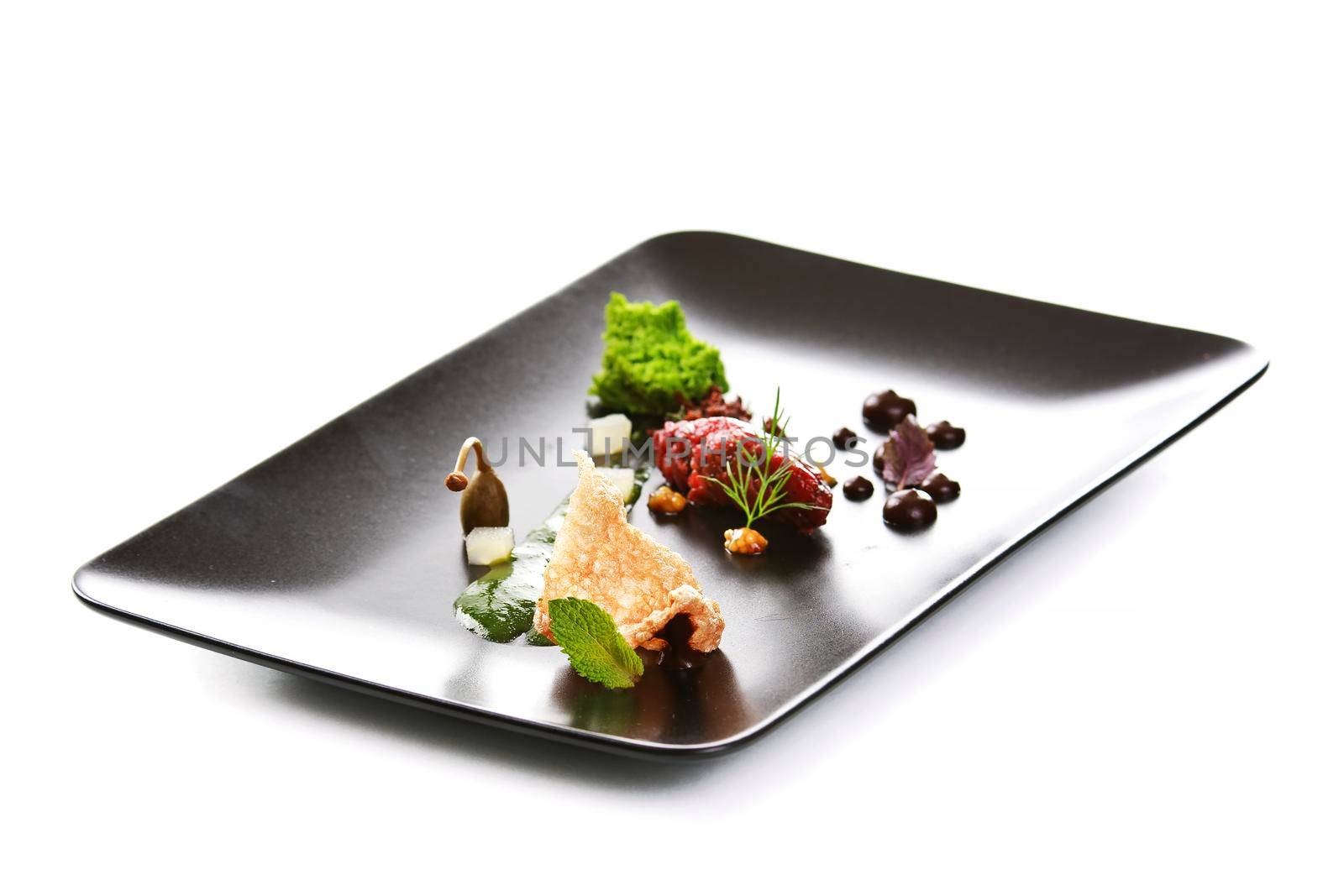 Molecular modern cuisine. Chips Pigskin with tartare or carpaccio of beef. Stock image. Isolated on white.