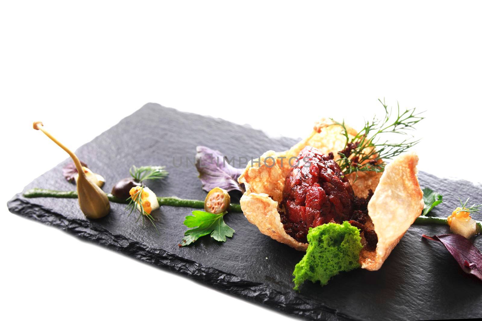 Molecular modern cuisine. Chips Pigskin with tartare or carpaccio of beef. Stock image. Isolated on white.