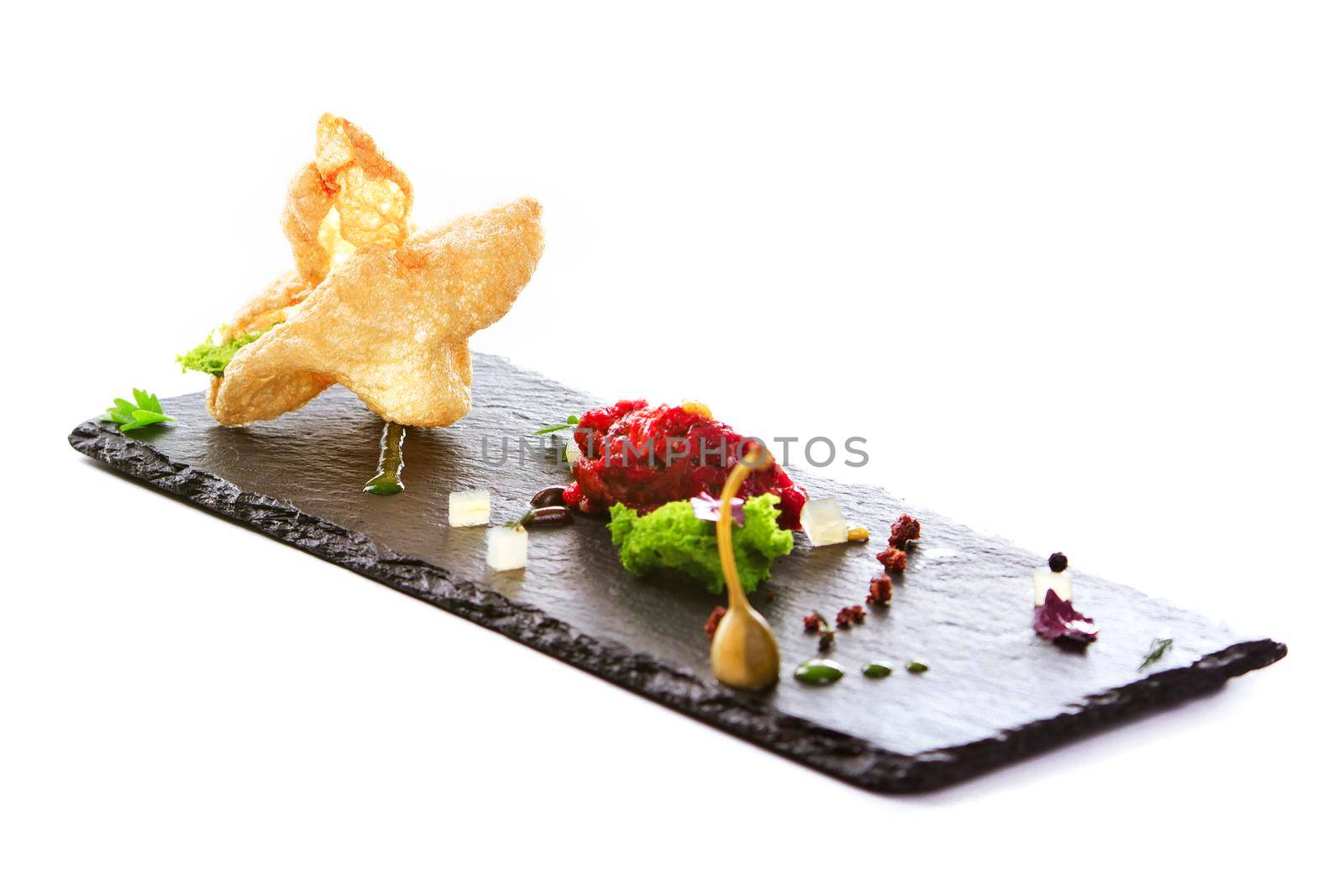 Molecular modern cuisine. Chips Pigskin with tartare or carpaccio of beef. Stock image. Isolated on white.