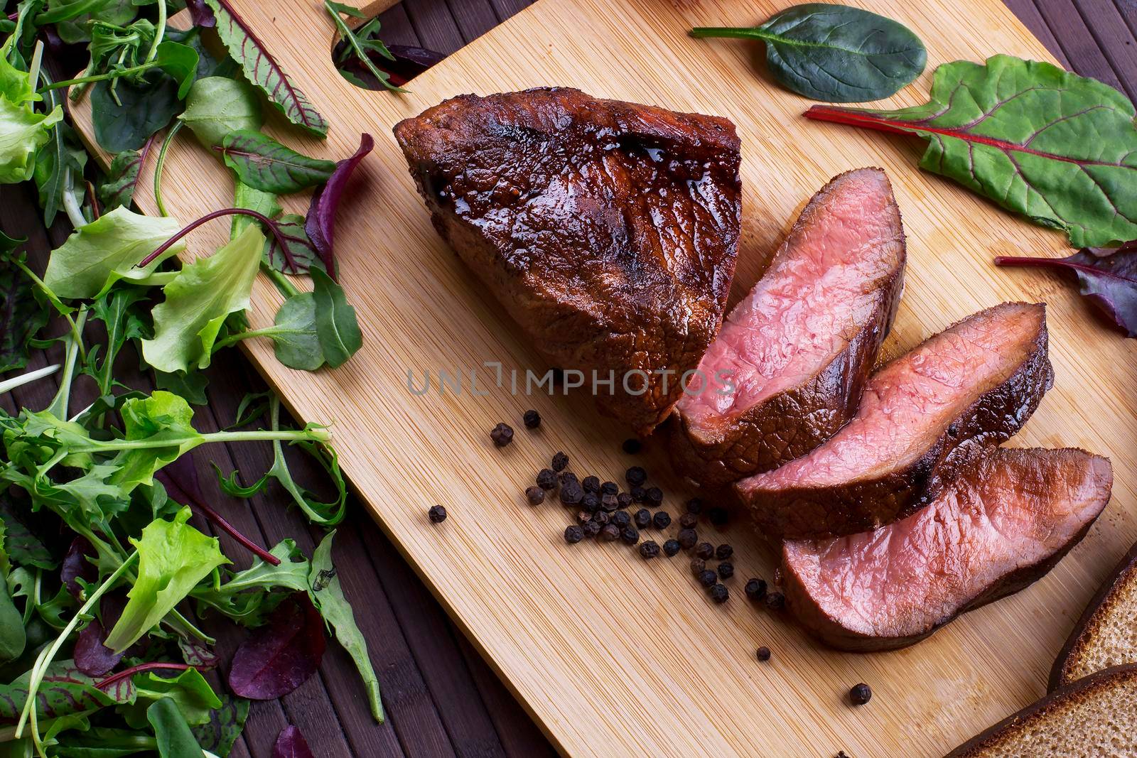 Close-up of Medium Rare Roast Beef with Fresh Herbs and Vegetables