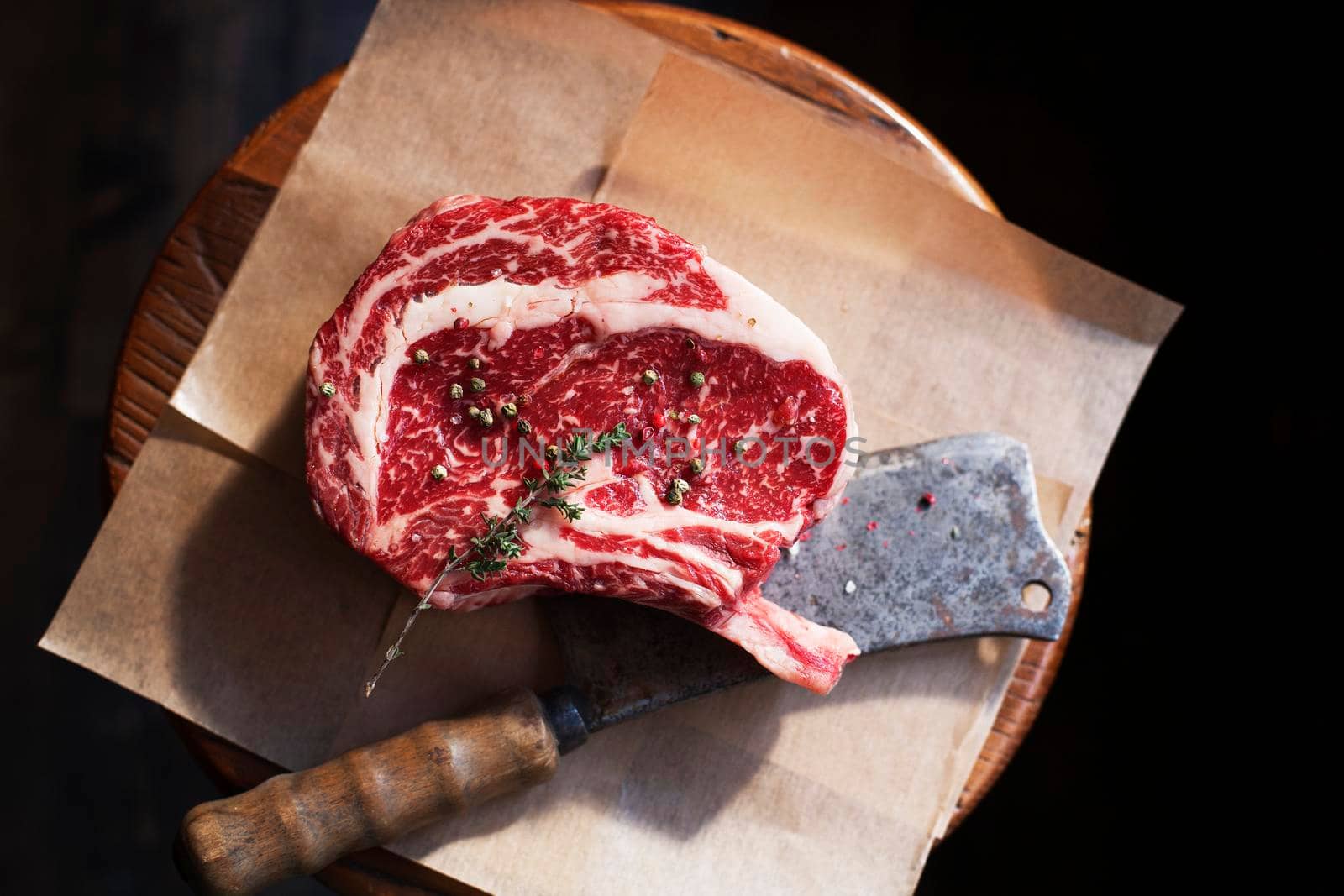 Bone In Rib Eye row Steak and knife for cutting meat on a wooden board. Stock image