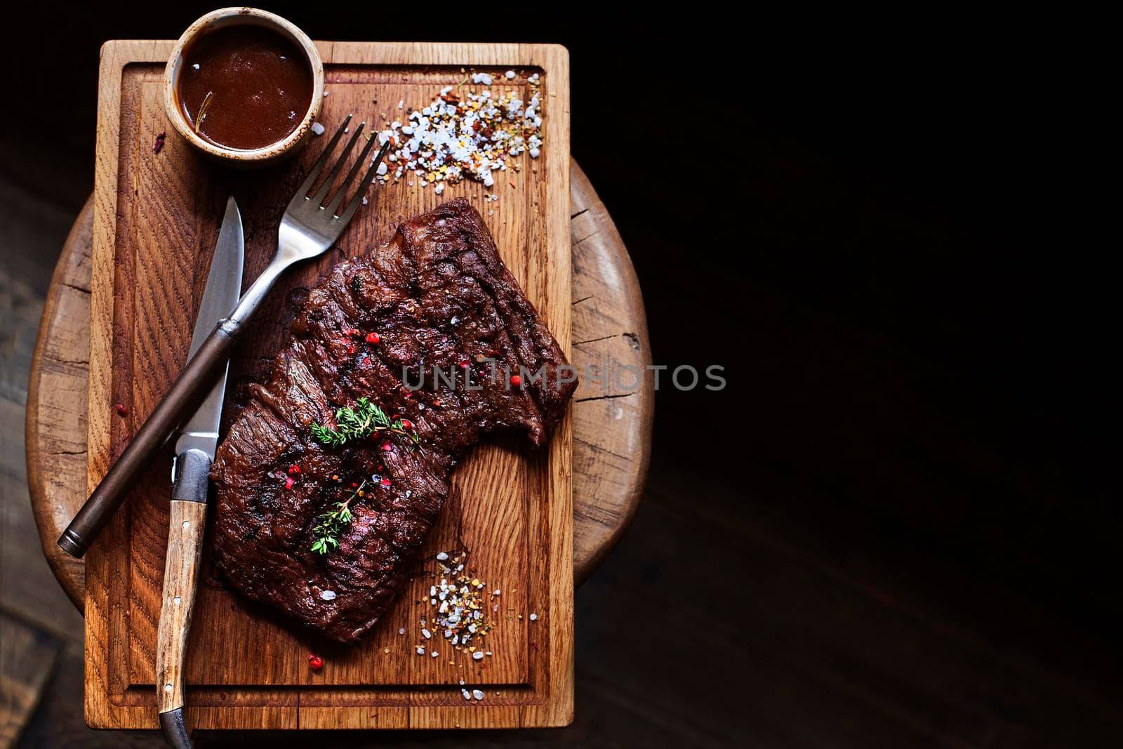 Beef steak. Piece of Grilled BBQ beef marinated in spices and herbs on a rustic wooden board over rough wooden desk with a copy space. Top view