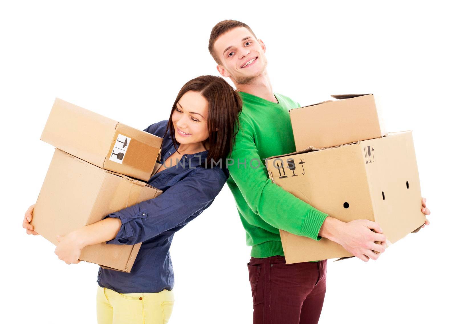 Young couple smile while holding large cardboard boxes. Vertical shot. Isolated on white.