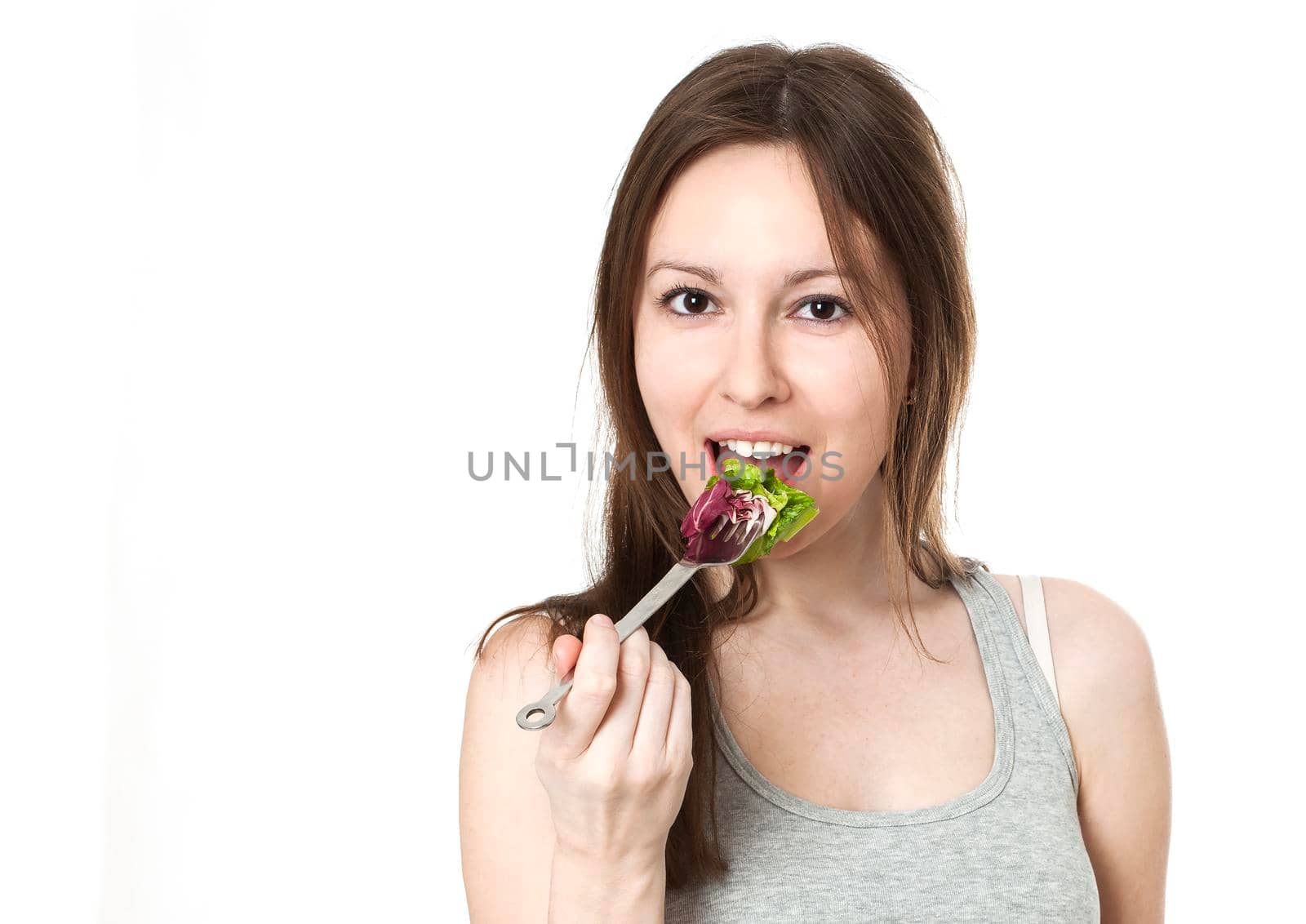 Happy young woman eating salad. by Jyliana