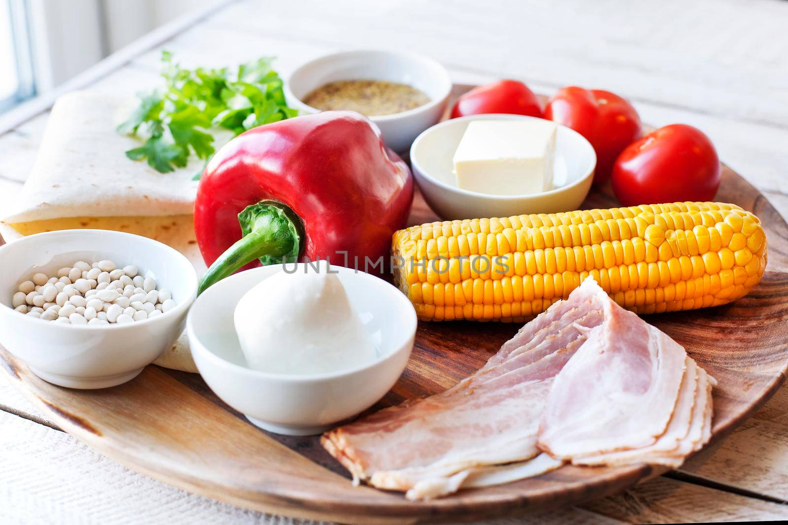 Ingredients for cooking Mexican Quesadilla wrap with vegetables, corn, sweet pepper and sauces on the parchment and table. horizontal view.