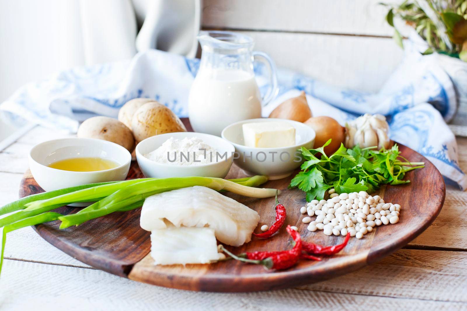 Wooden plate with ingredients from fish and vegetables for cooking cutlets with mashed potatoes