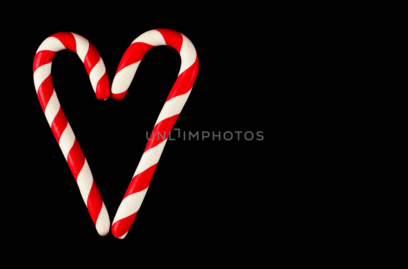 Valentine Heart made from Christmas candies isolated on black background