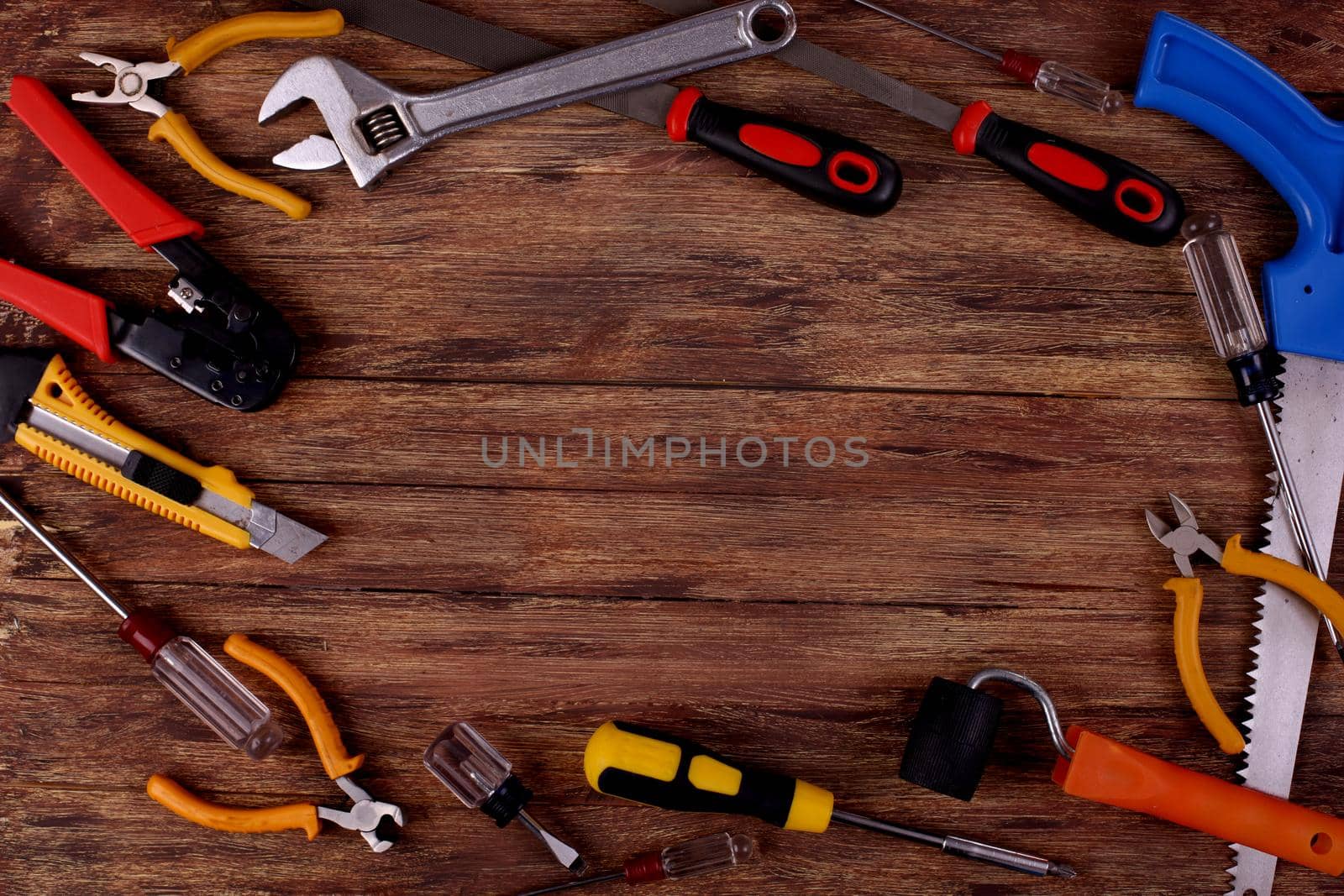 This is an overhead photo of construction tools and brush with copy space on a wood background. There is a lot of space