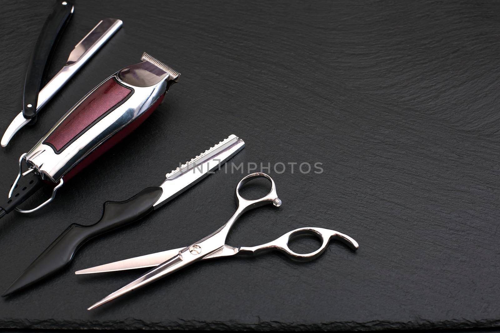 Barber shop equipment on Black background with place for text. Professional hairdressing tools. Comb, scissor, clippers and hair trimmer isolated.