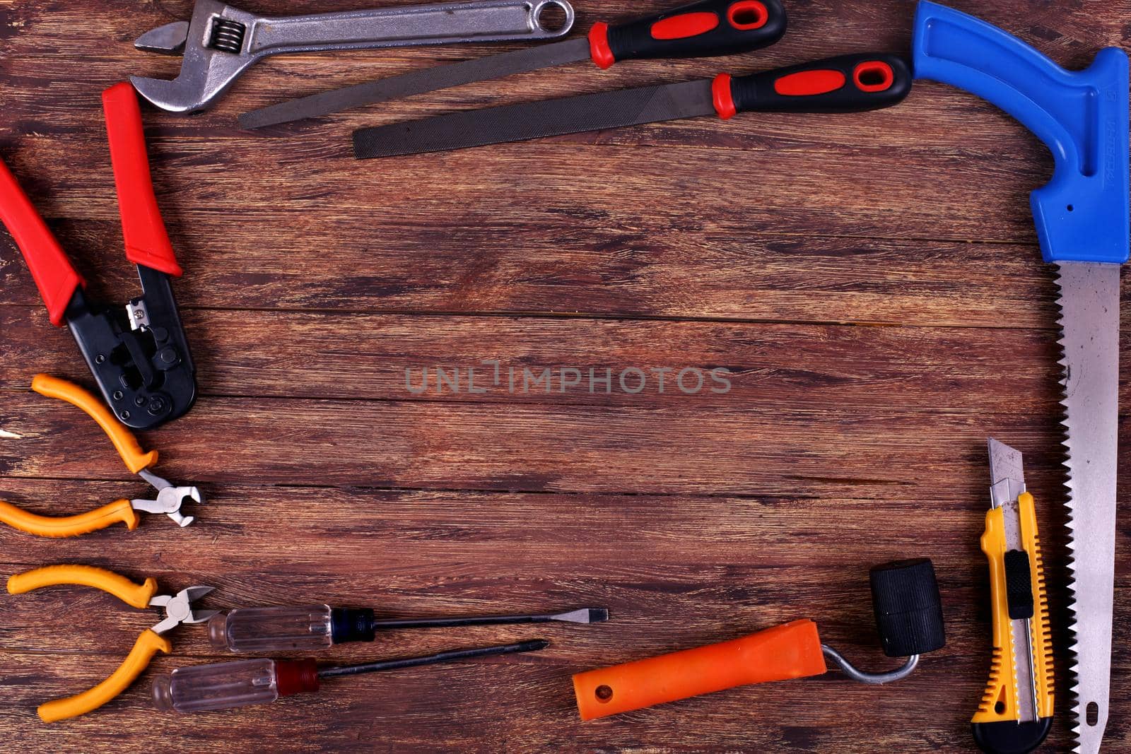 This is an overhead photo of construction tools and brush with copy space on a wood background. There is a lot of space