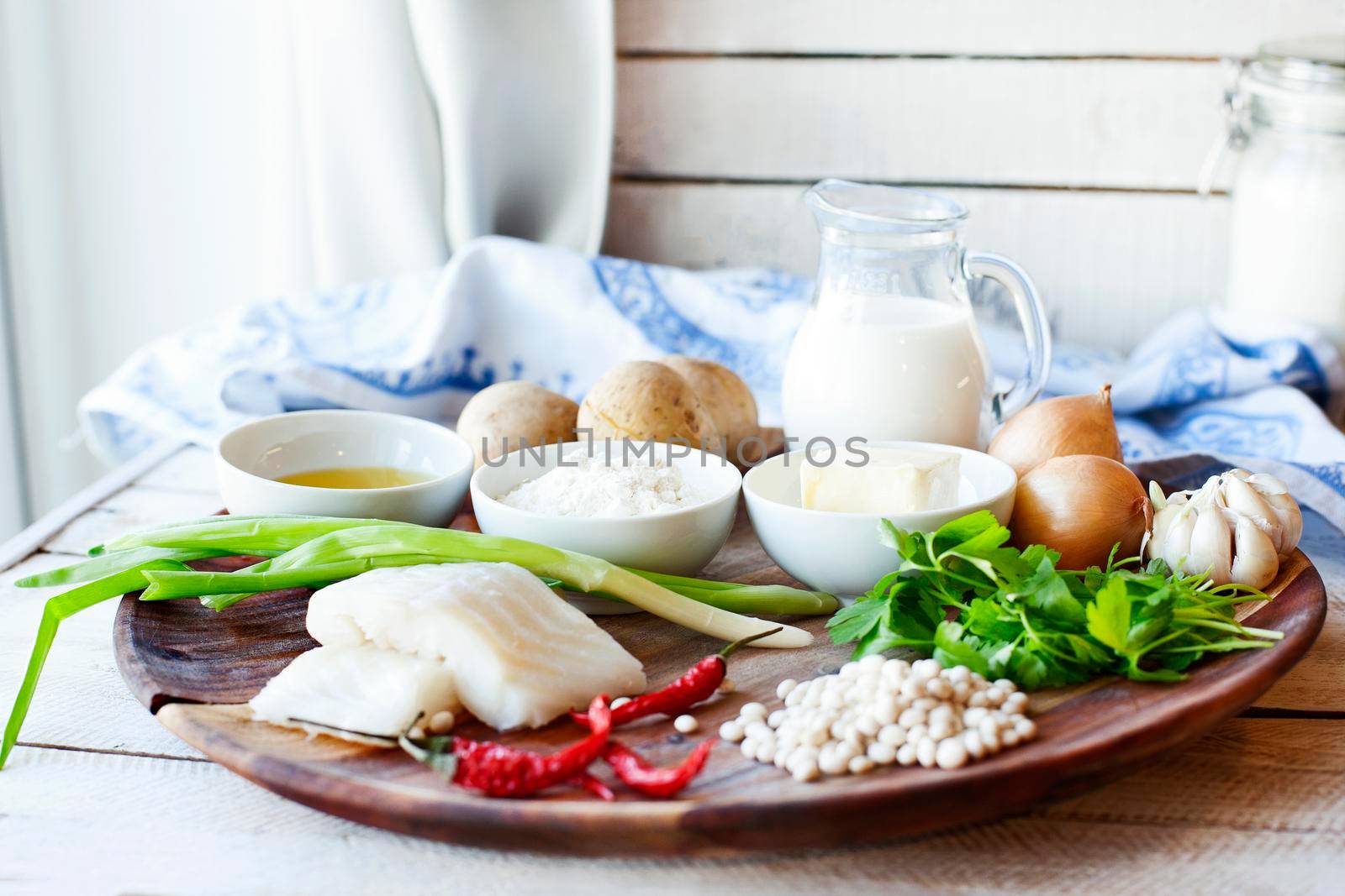 Wooden plate with ingredients from fish and vegetables for cooking cutlets with mashed potatoes