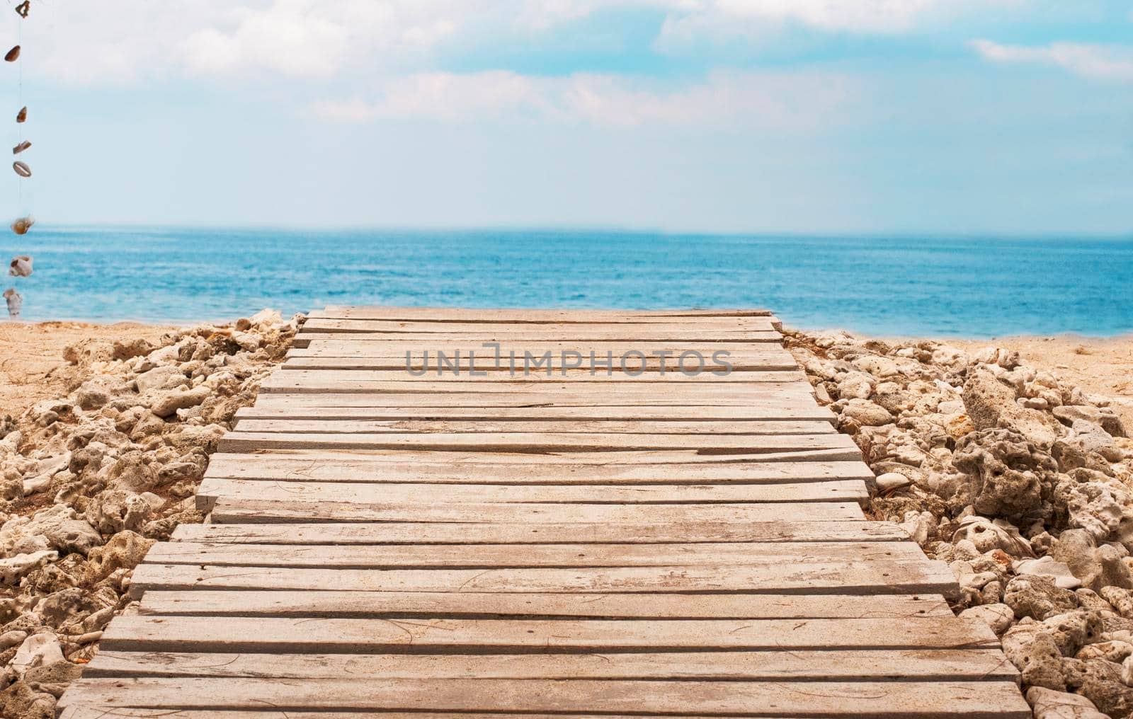 Wooden platform on beach with seascape and cloudy sky