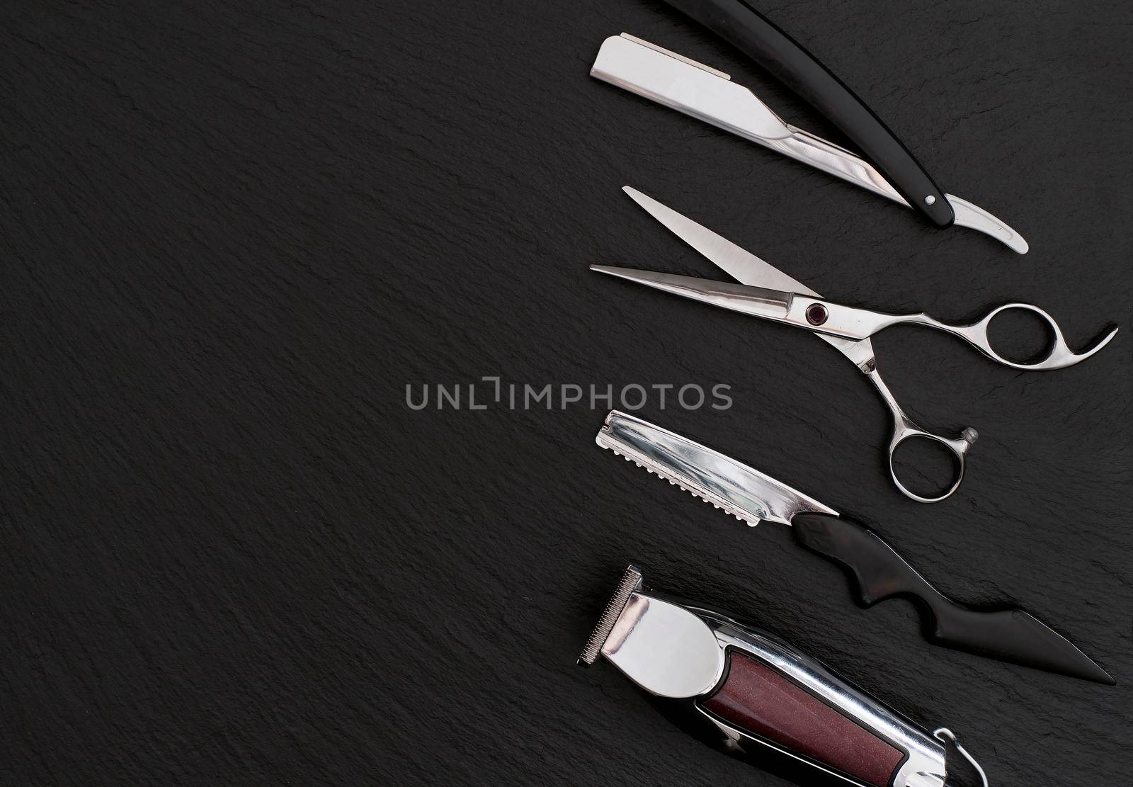 Barber shop equipment on Black background with place for text. Professional hairdressing tools. Comb, scissor, clippers and hair trimmer isolated.