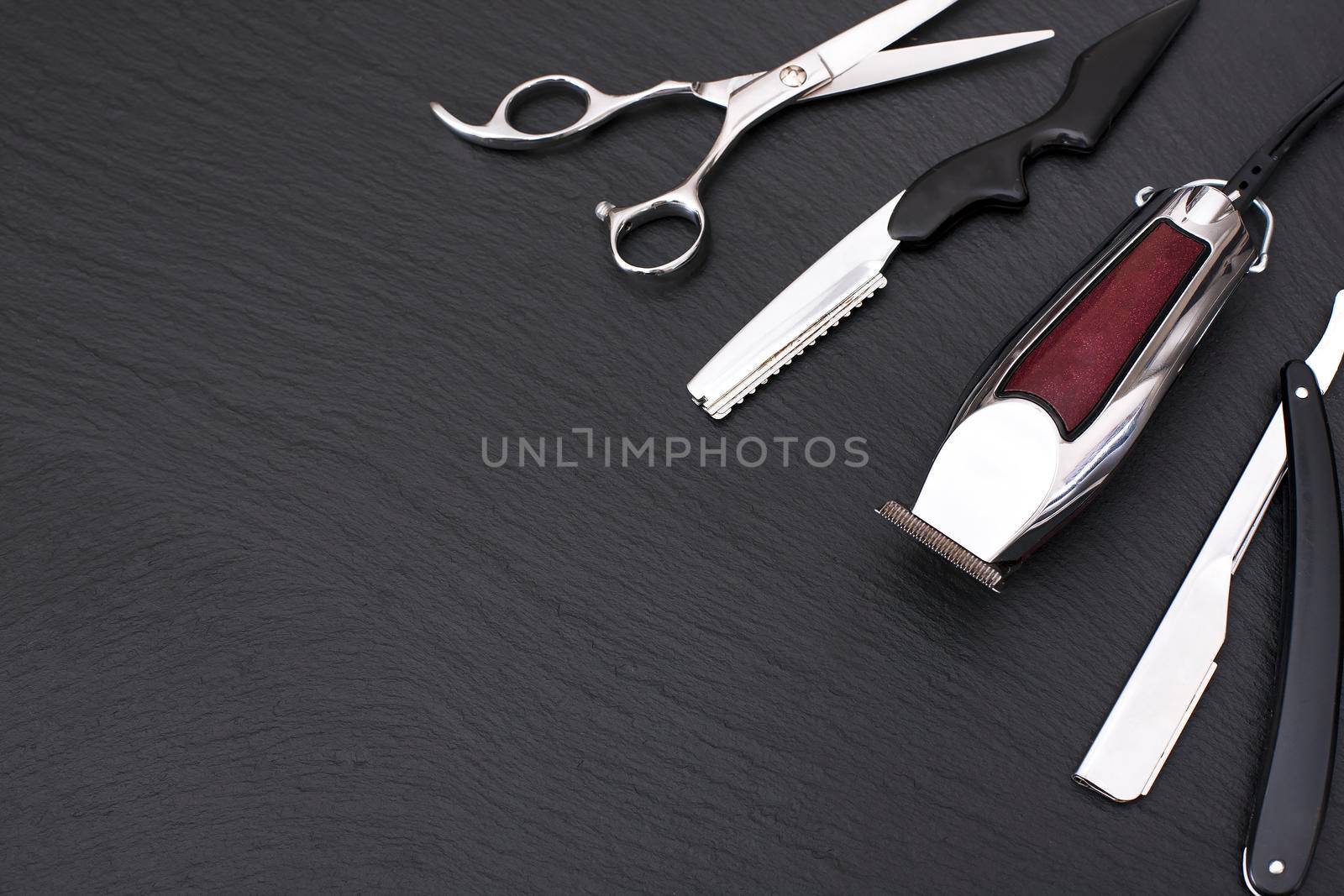 Barber shop equipment on Black background with place for text. Professional hairdressing tools. Comb, scissor, clippers and hair trimmer isolated.