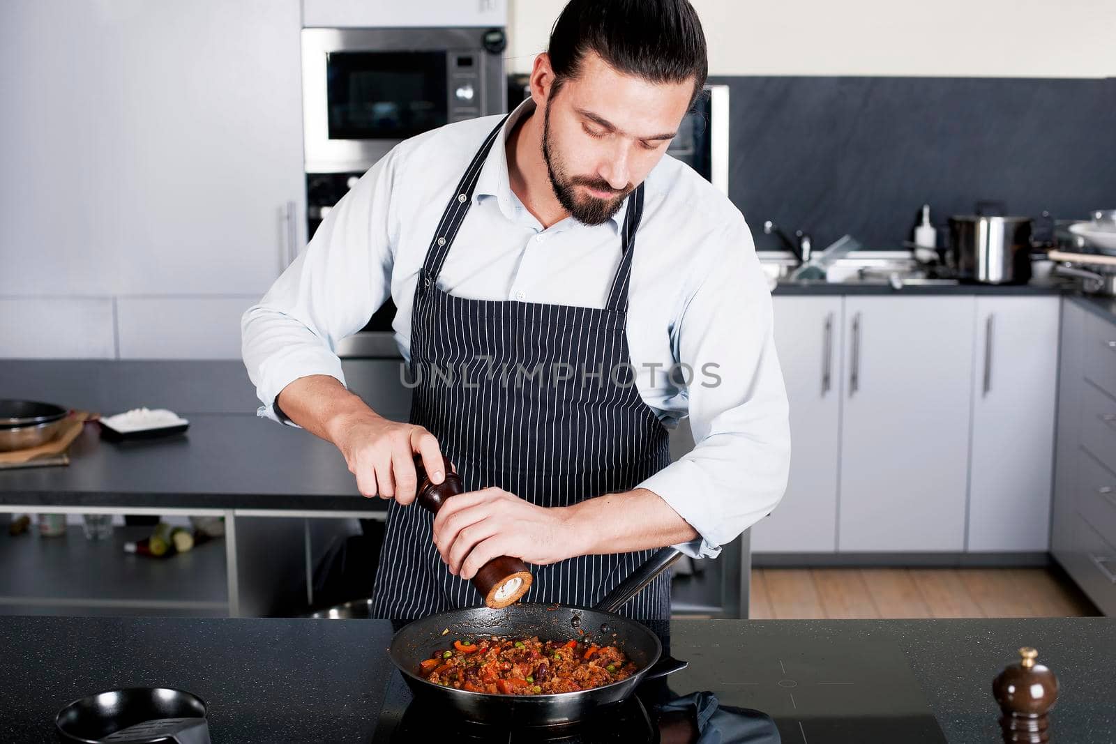 Chef preparing dishes in a frying pan by Jyliana