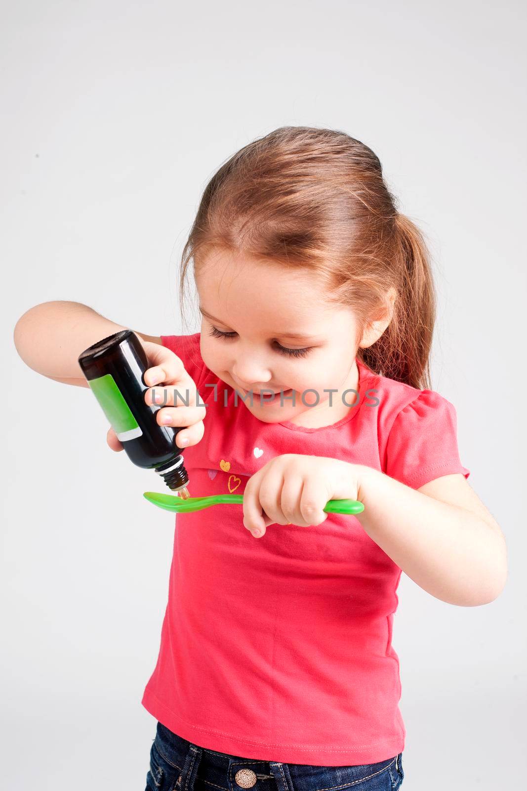 Cute Baby Girl Drinking Medicine Syrup - Stock image