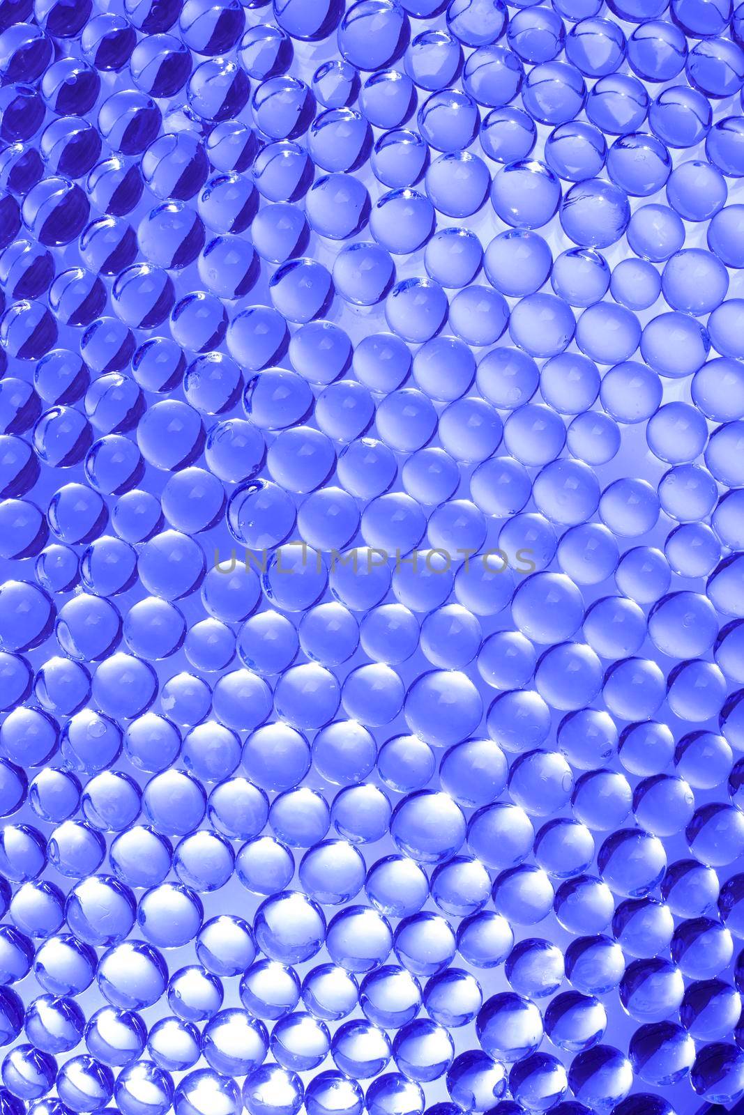 Background of glass beads in blue with highlights. Stock image.