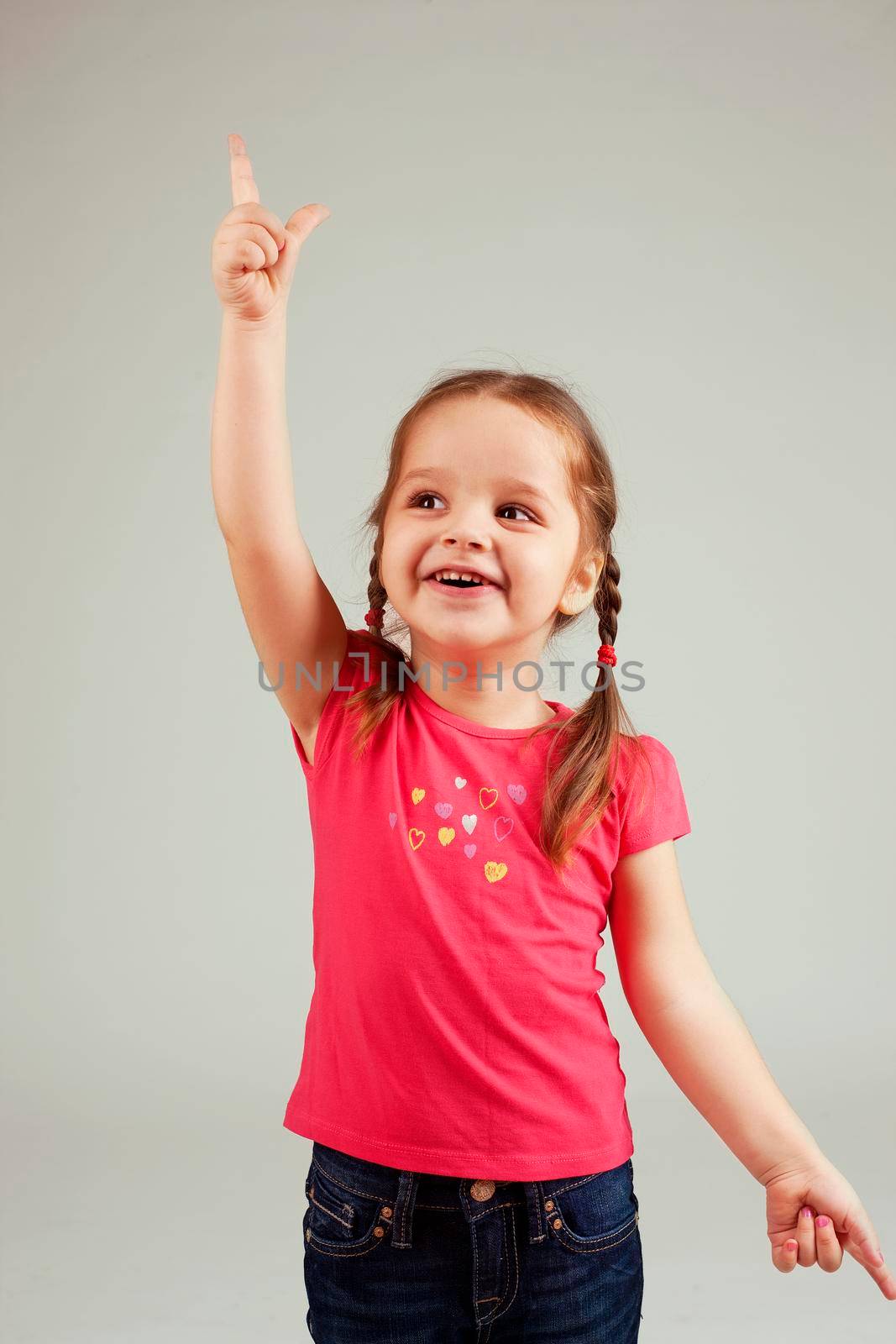 Cute child smiling and pointing up with finger