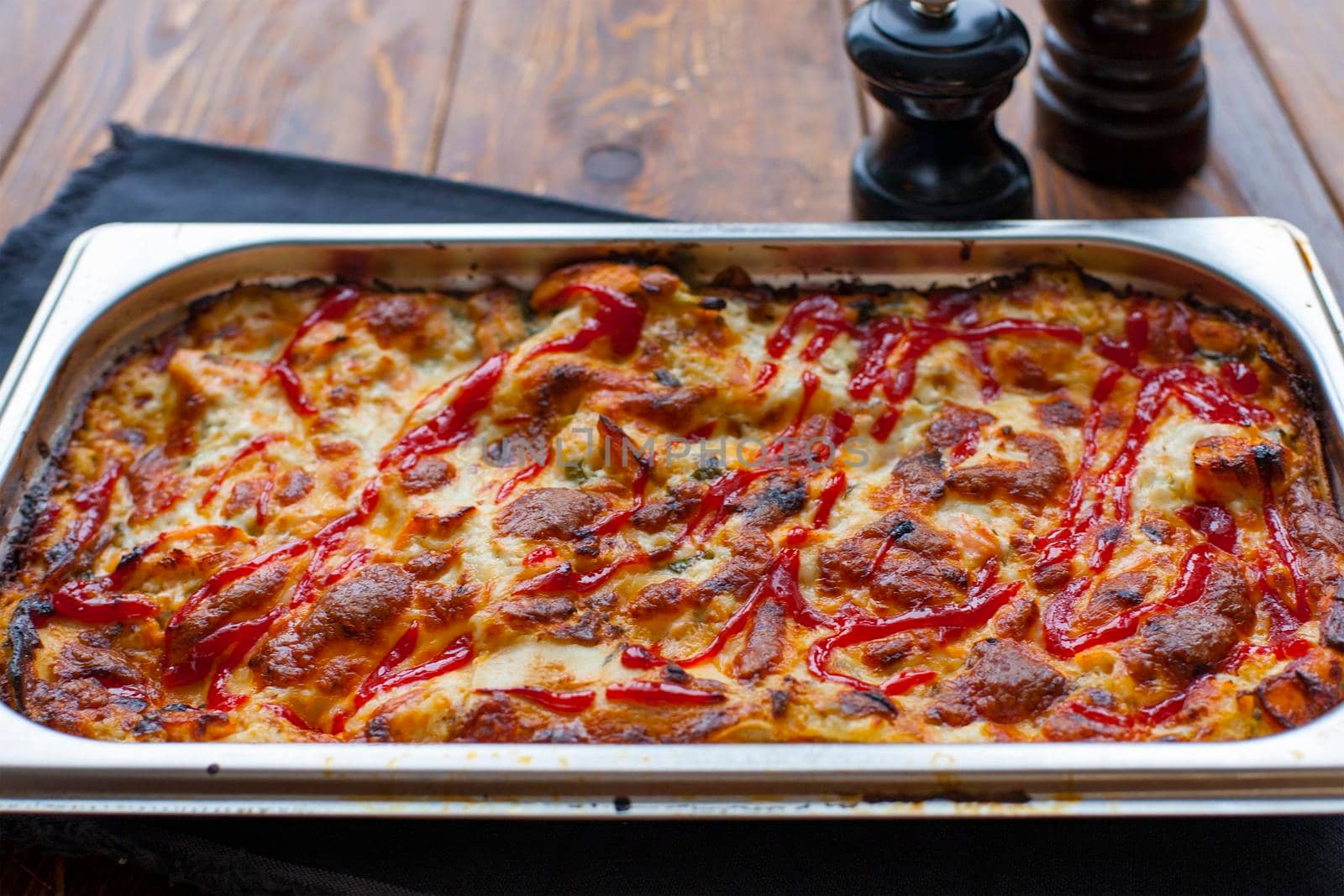 Italian Food. Hot tasty lasagna in ceramic casserole dish on Wooden Table