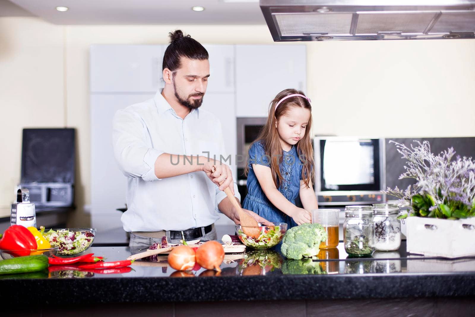 Young father and daughter cooking meal together