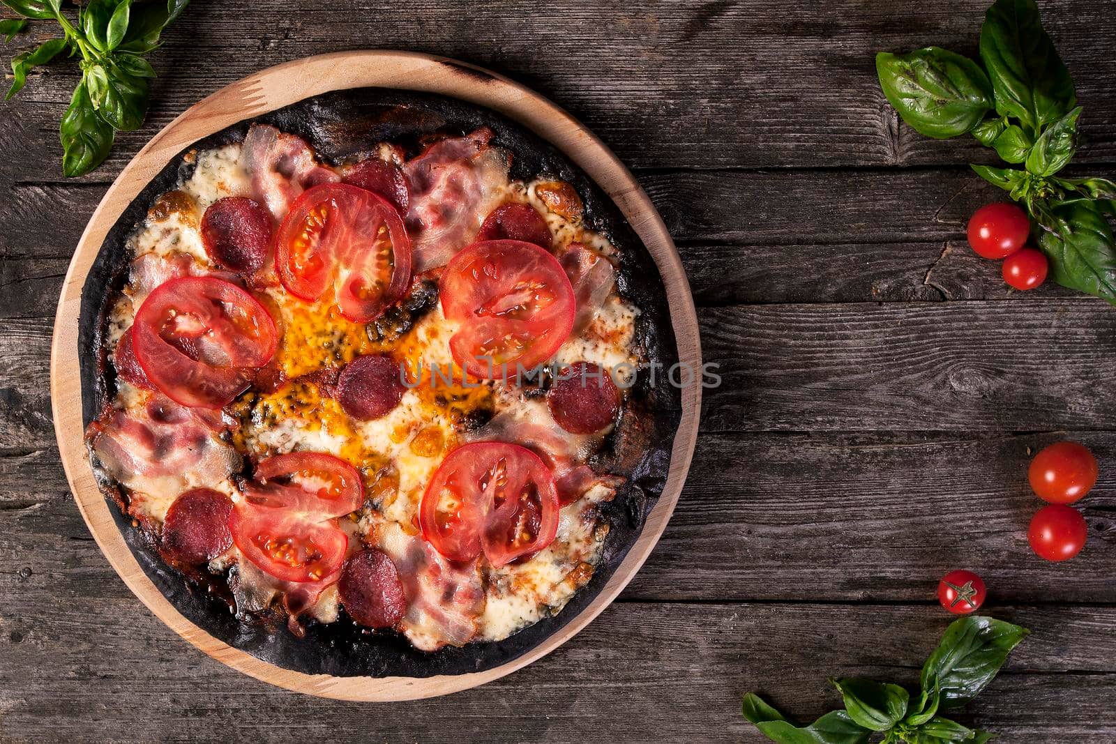 Black pizza with salami, ham, tomato and cheese by Jyliana