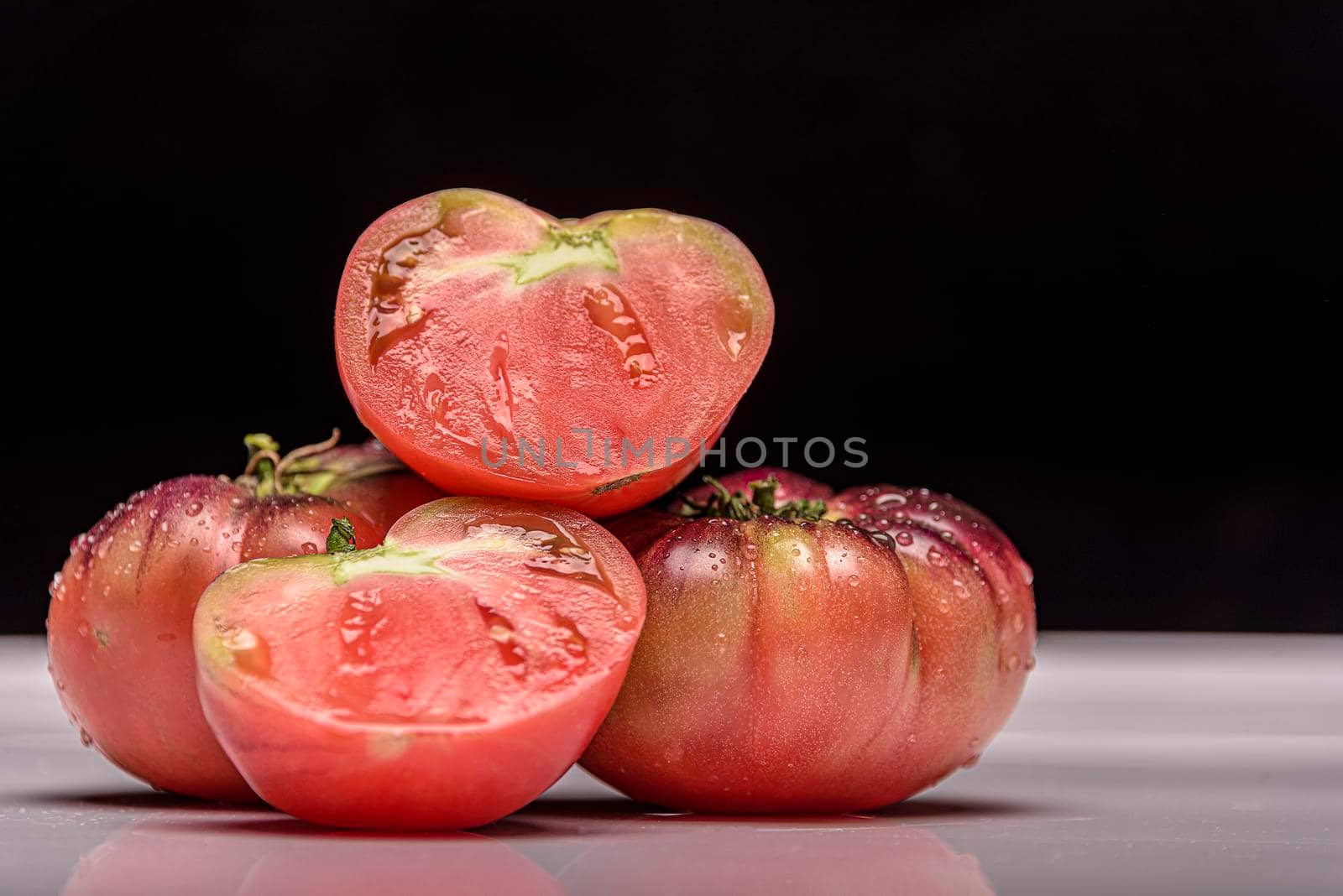 Beautiful fresh tiger tomatoes on dark background