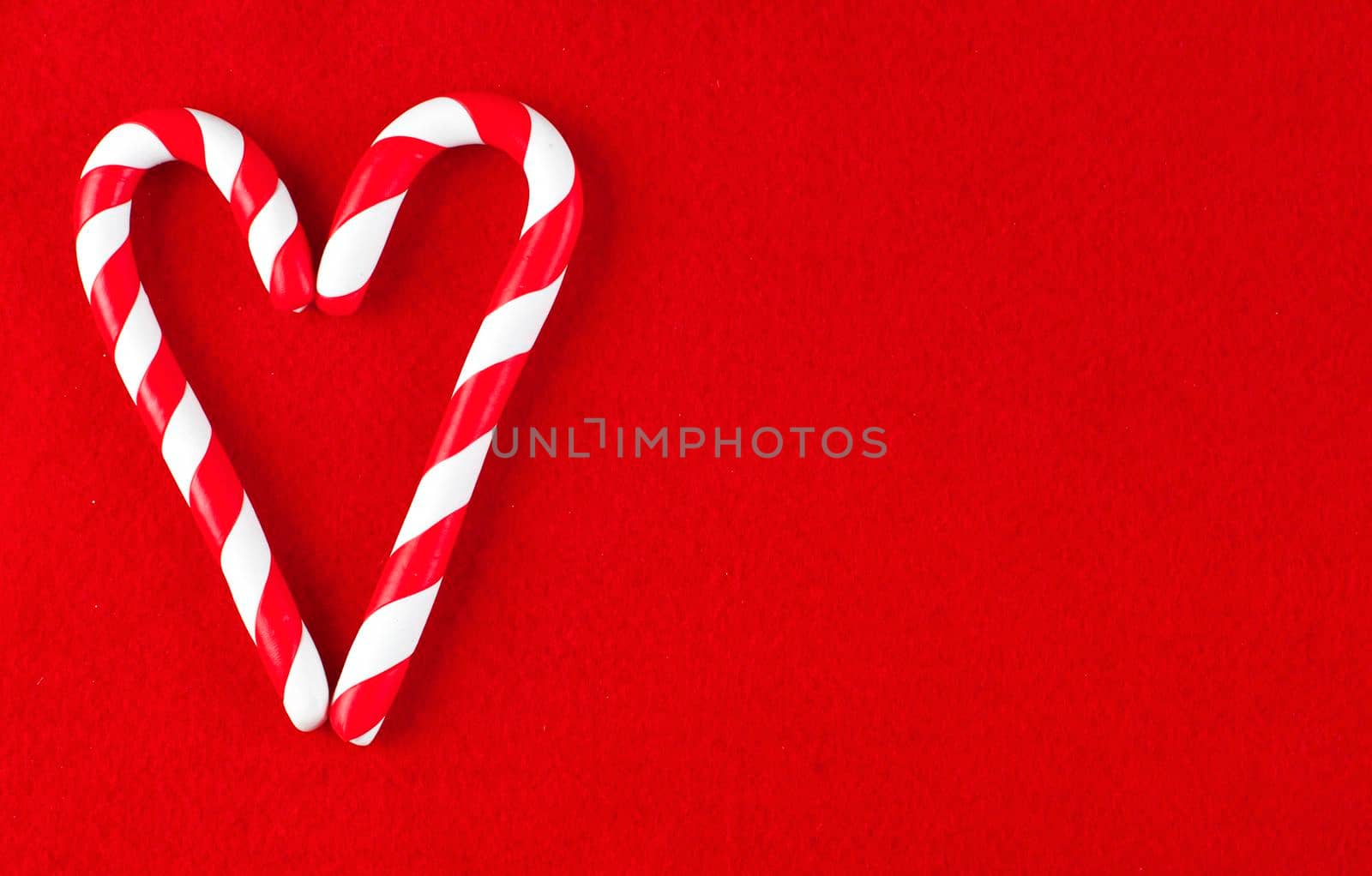 Valentine Heart made from Christmas candies isolated on red background