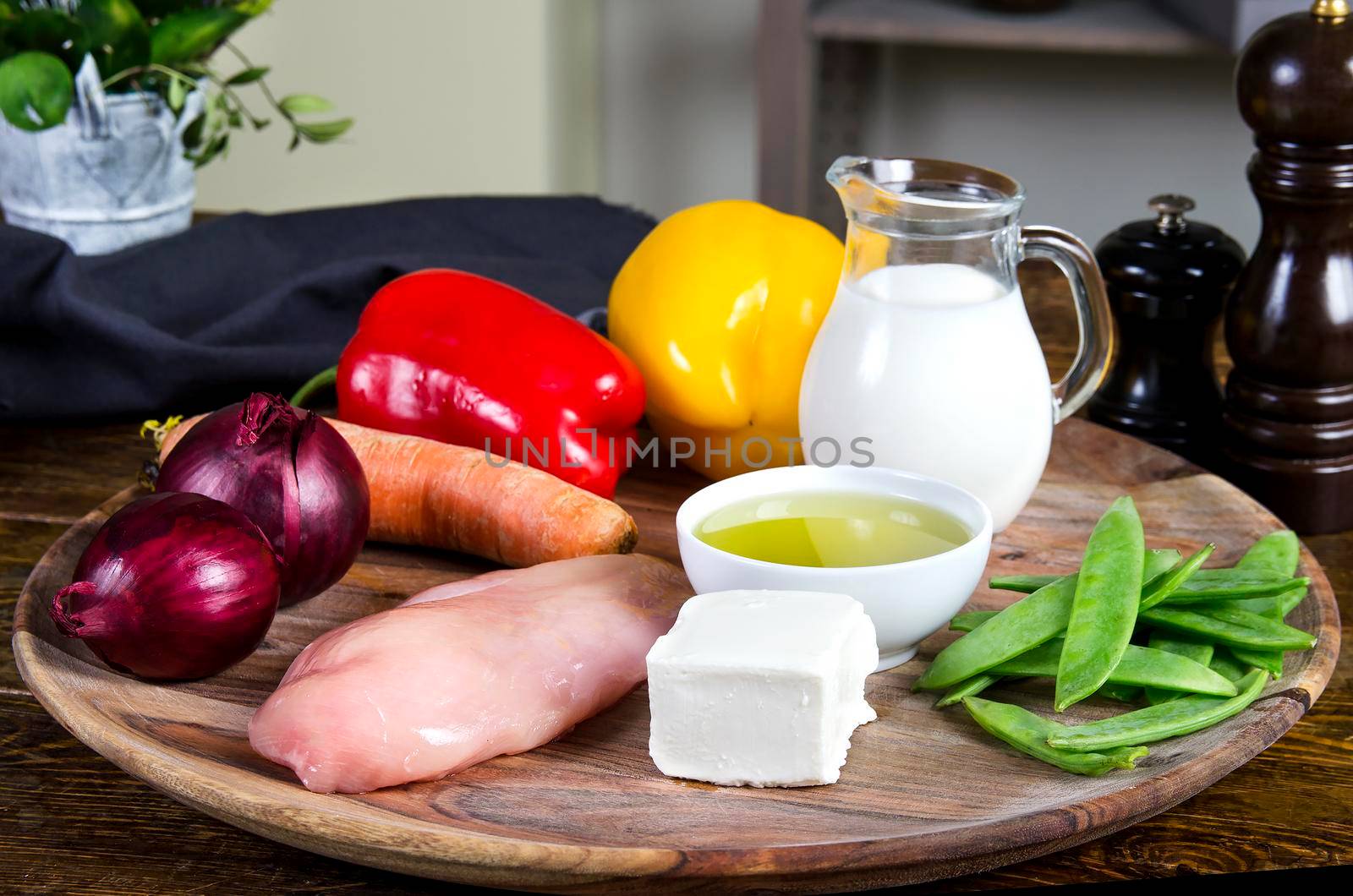 Chicken breasts with fresh healthy vegetables, oil and spices. Raw products on the wooden background - Stock image