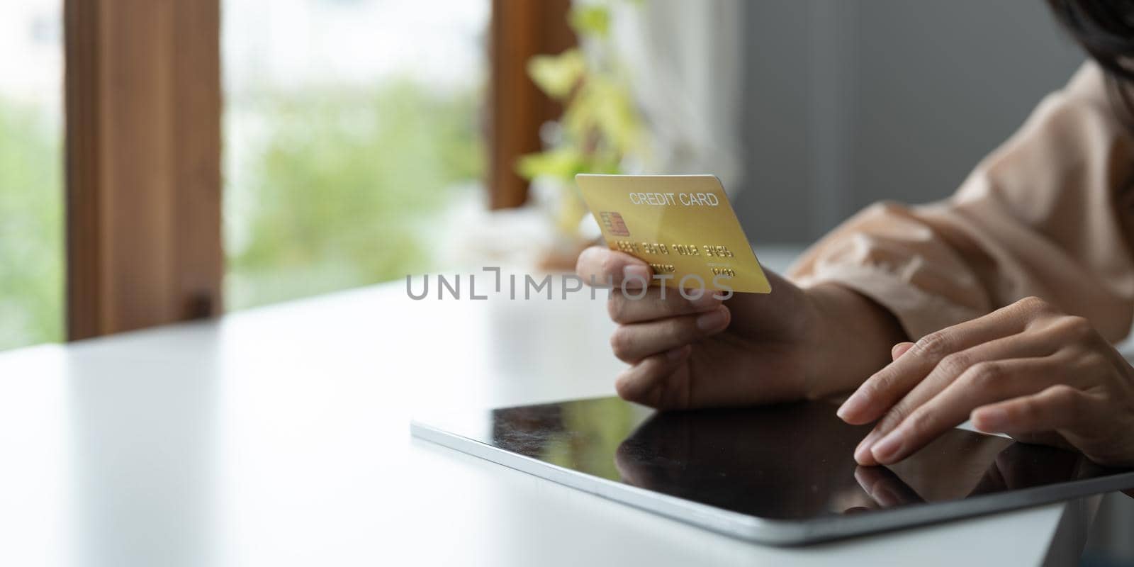 Close up hands holding credit card and using digital tablet. Online shopping.