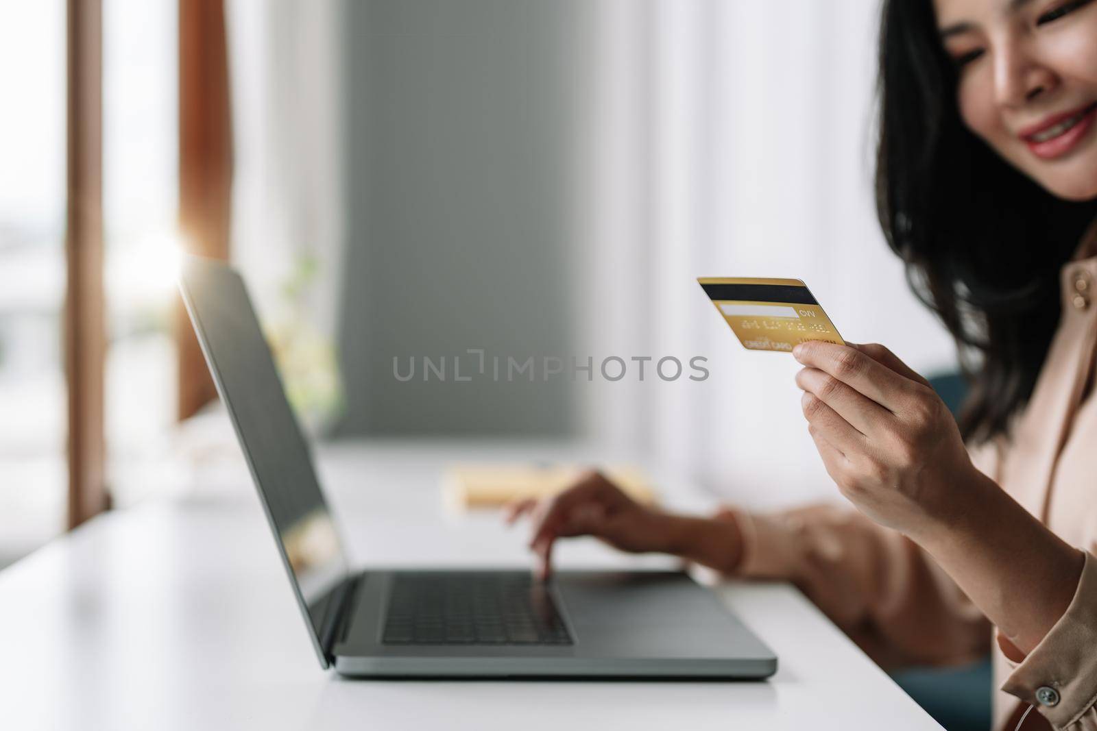 Close up of asian girl hold bank credit card and type on laptop, shopping online using computer, buying goods or ordering online, entering bank accounts and details in online banking offer