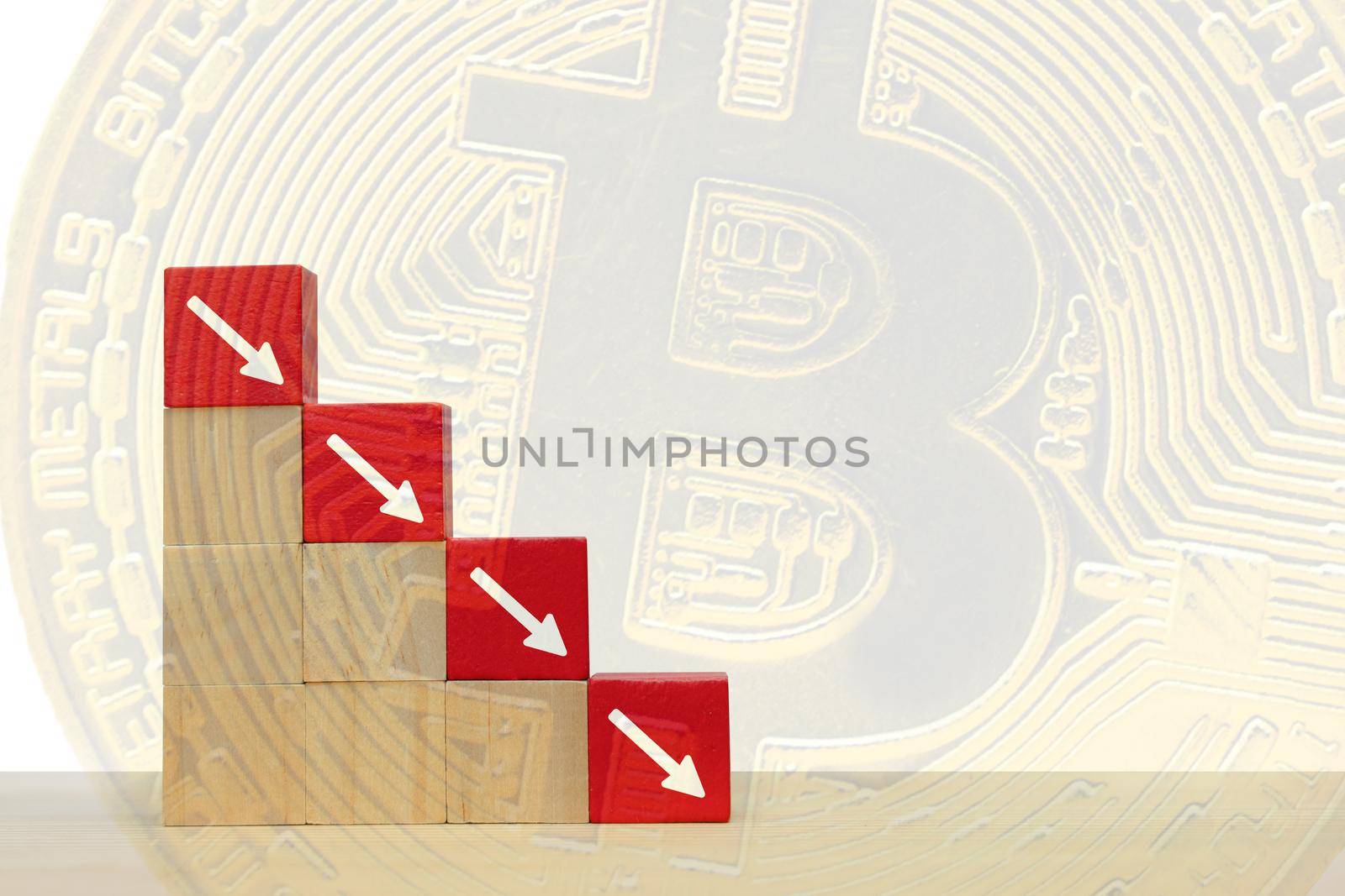 Arrow pointing down on red wooden block.  Symbol of the fall of Bitcoin and cryptocurrency on abstract background