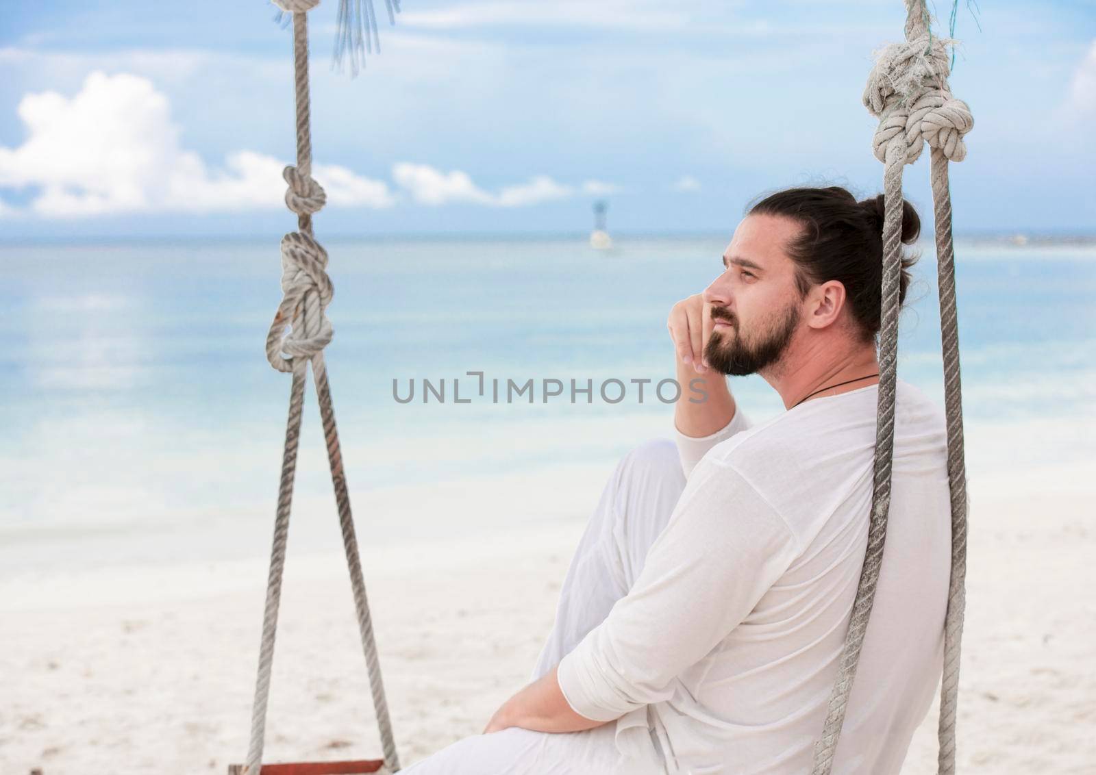 Businessman wearing white freelance sitting on beach swing and dreaming