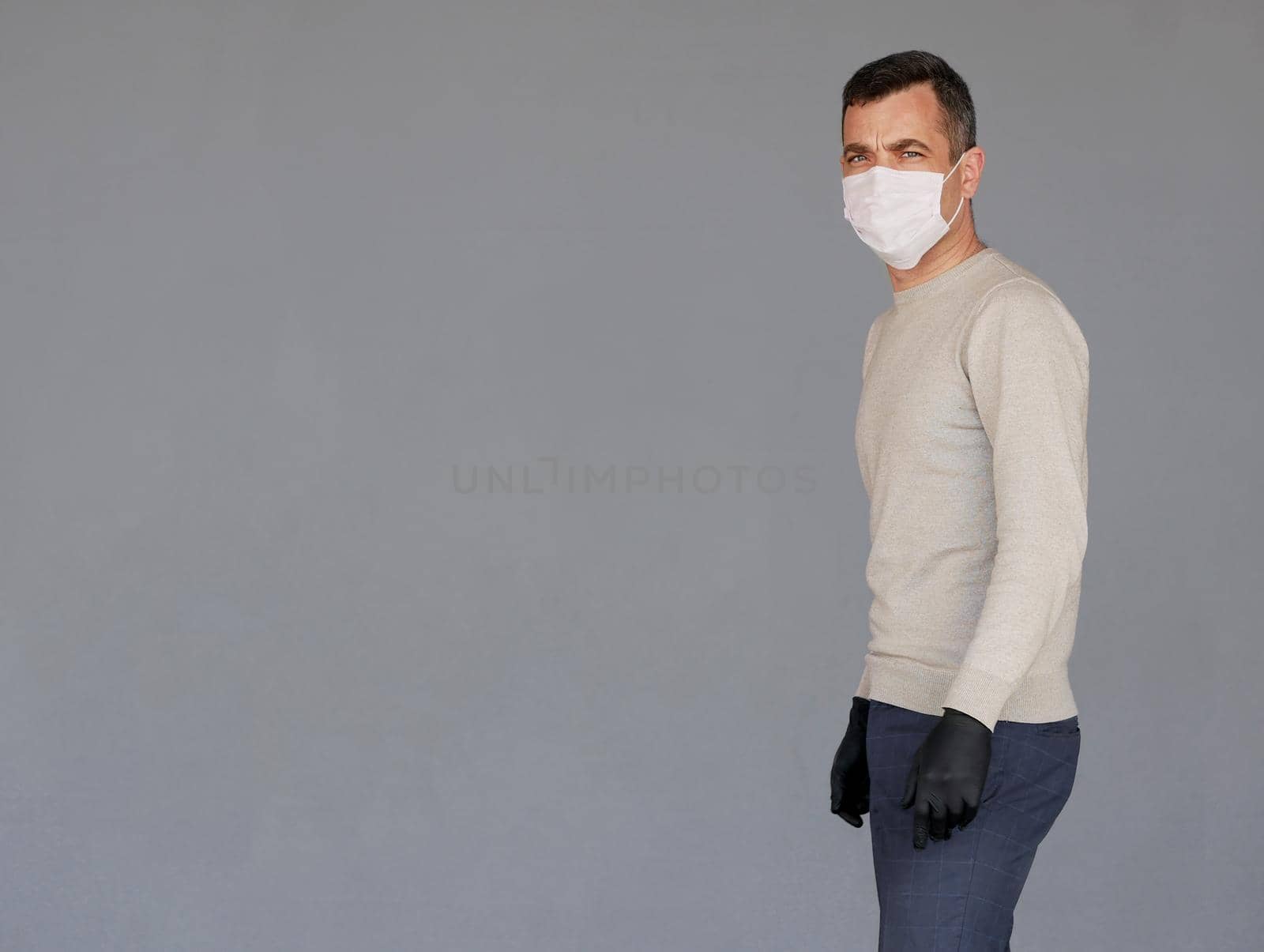 Man wearing surgical face mask isolated on grey by Jyliana