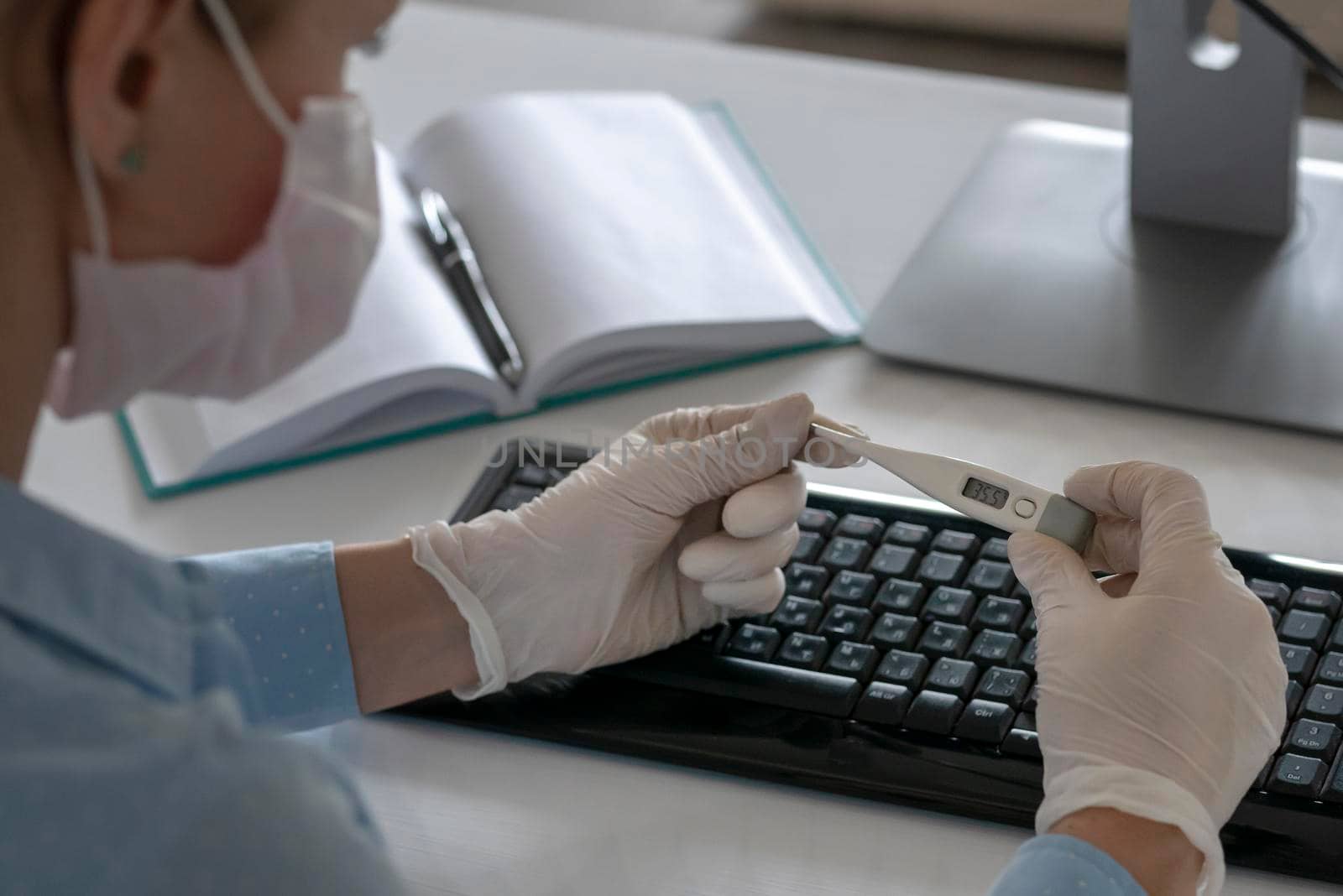 Sick woman holding thermometer in hands, working on a laptop home quarantine isolation Covid-19 pandemic Corona virus. Distance online work. Pills and a medical mask