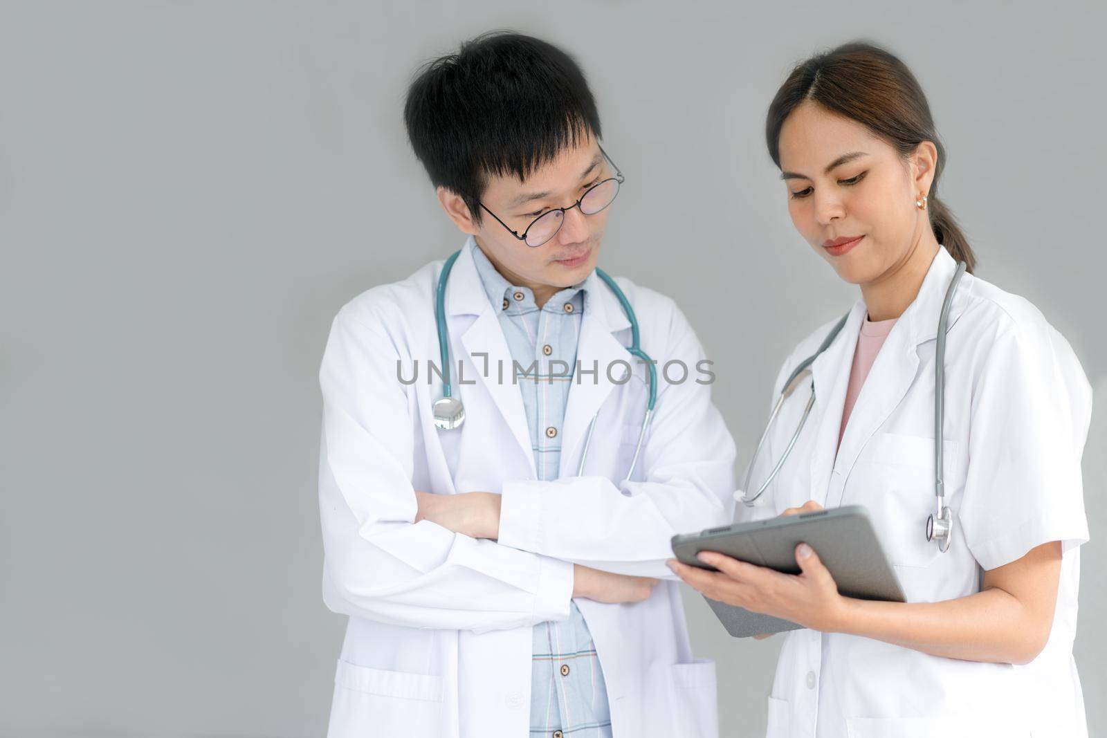 Team of doctors consults about patients by tablet for Telemedicine treatment.