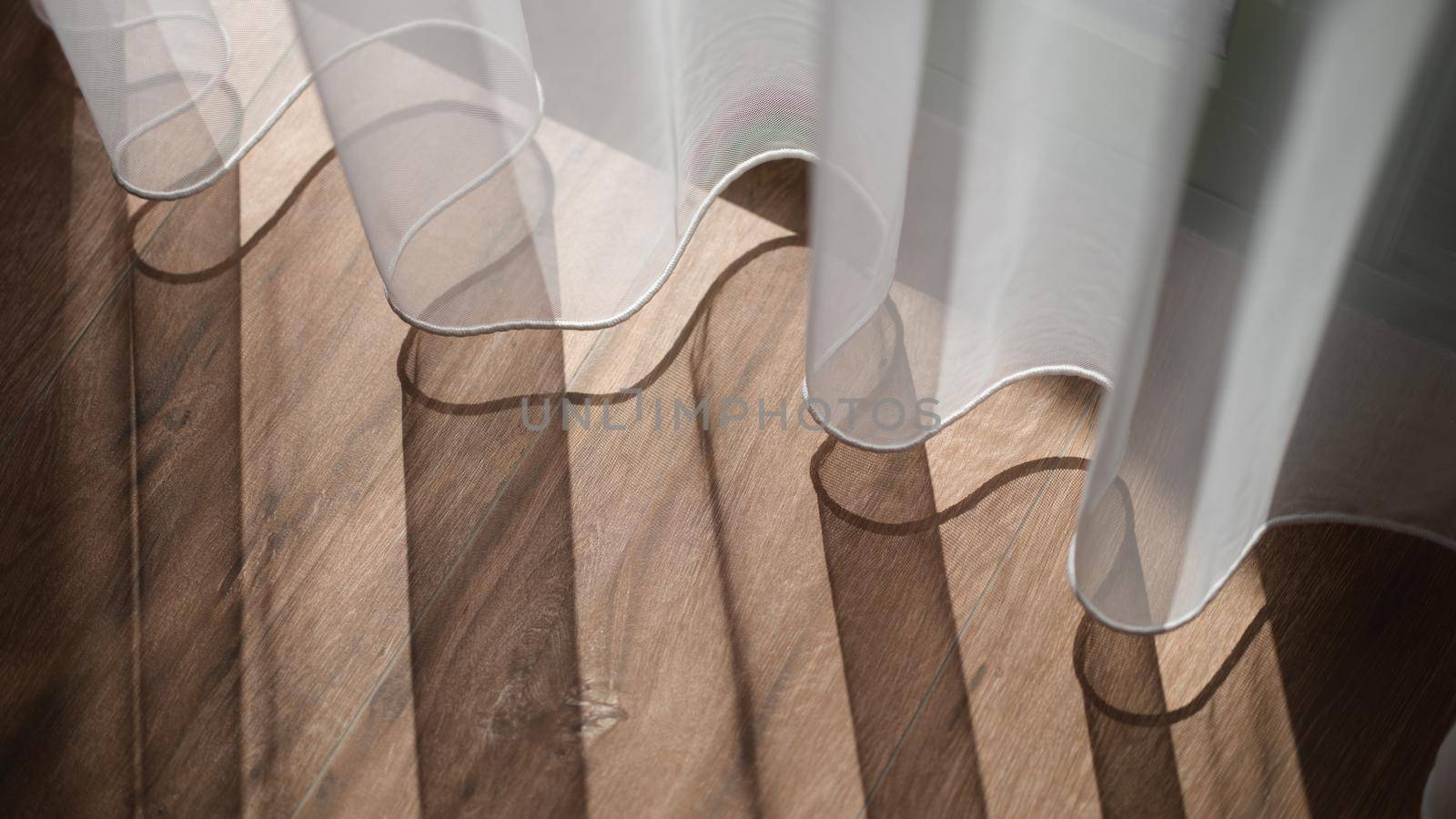 Sunlight falling on wooden floor and creating shadow from curtains background. Interior design sewing curtains concept