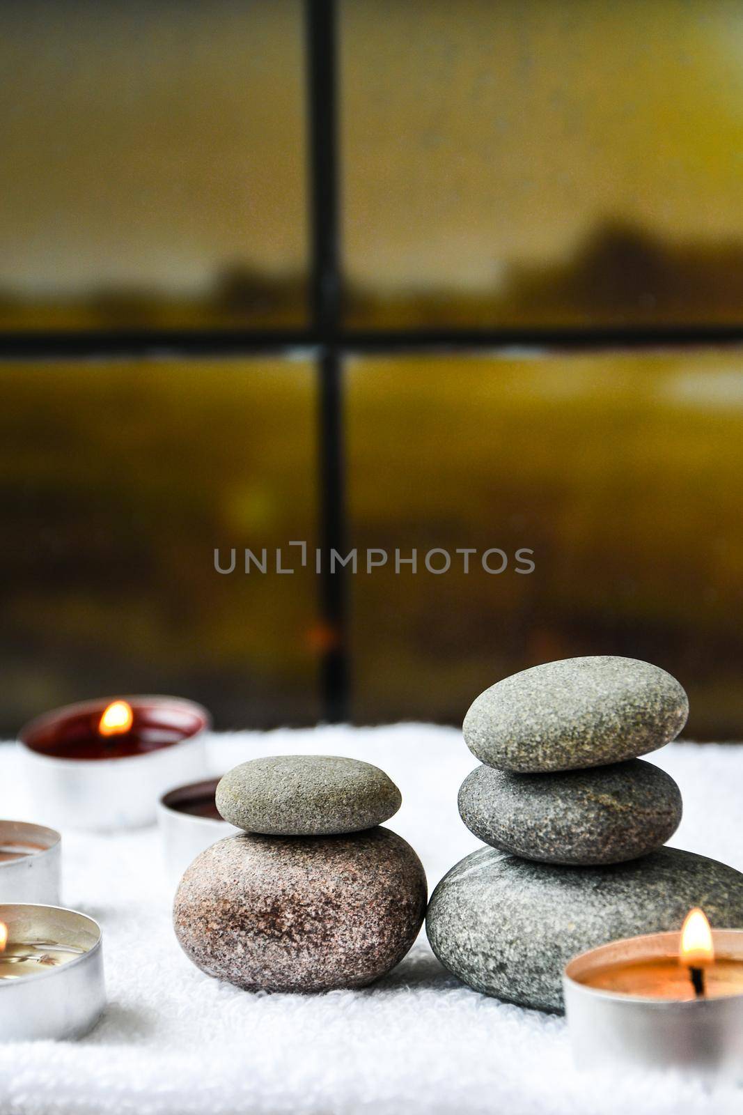 Zen concept, spa pebbles stones and burning aroma candles on blurred background, Treatment aromatherapy and massage, copy space for text